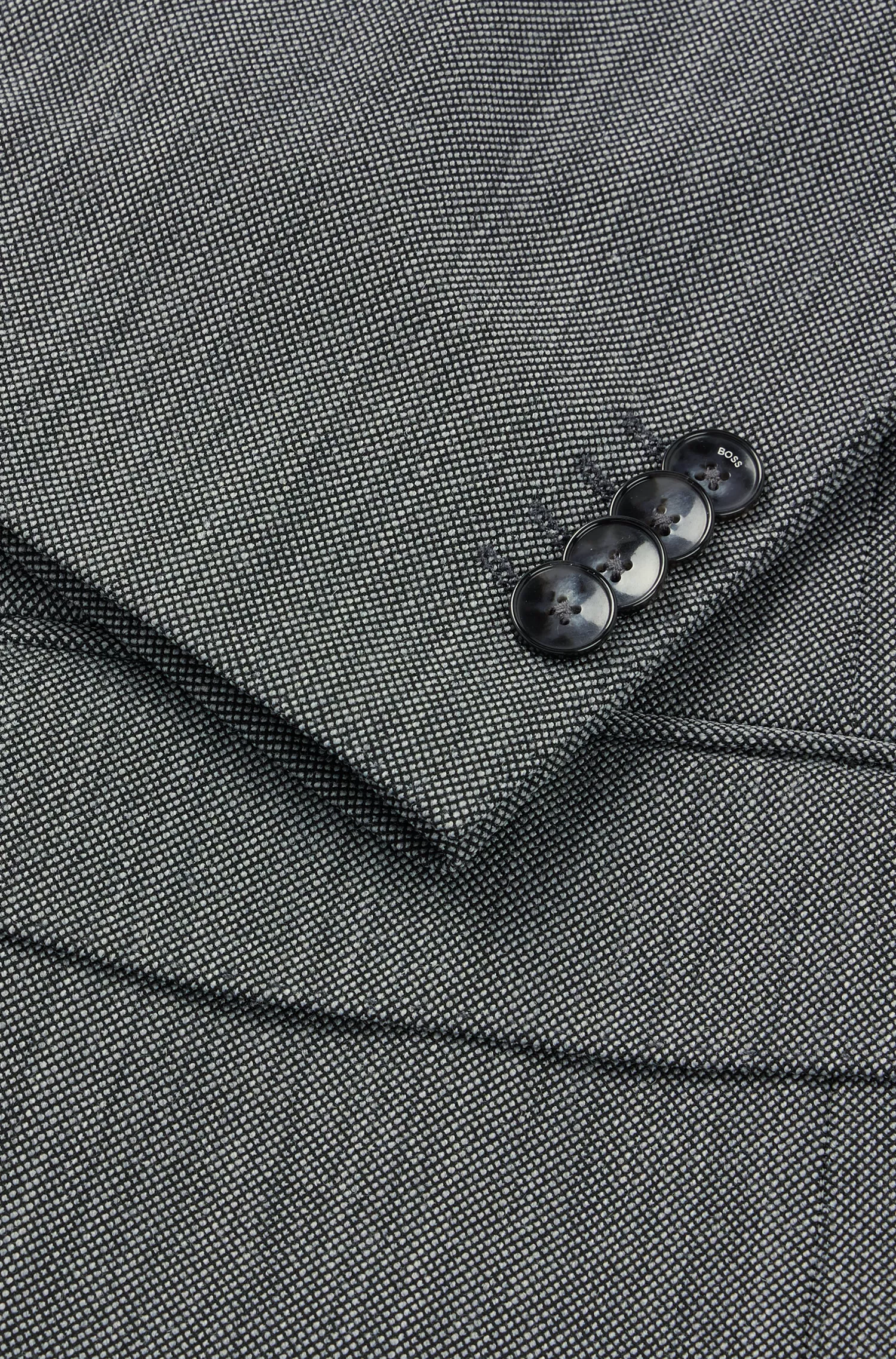Terno BOSS preto, corte regular, em tecido micropadronizado resistente a amassados.