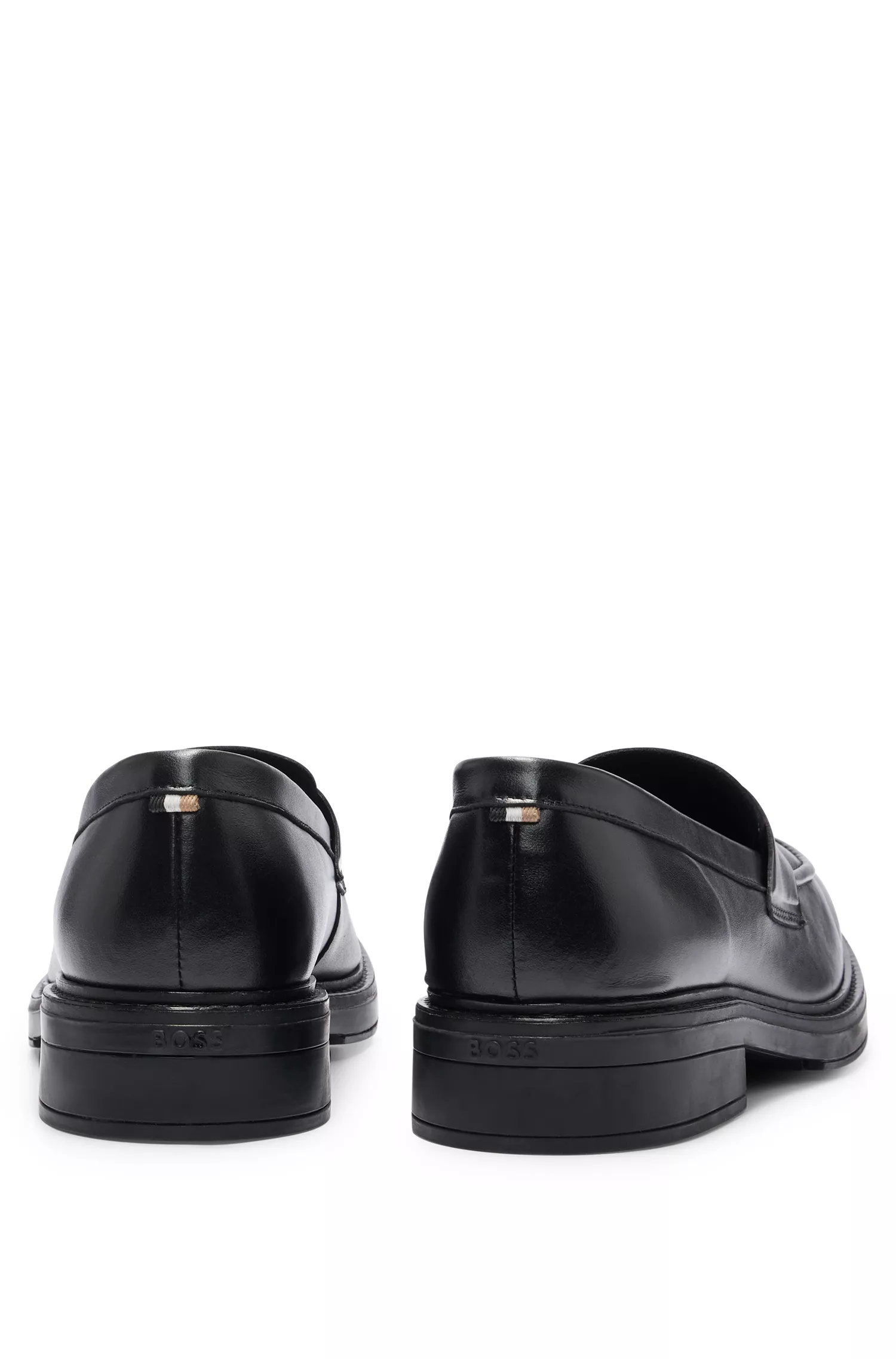 Mocassins BOSS em couro preto com detalhes em formato de moeda e logotipo.