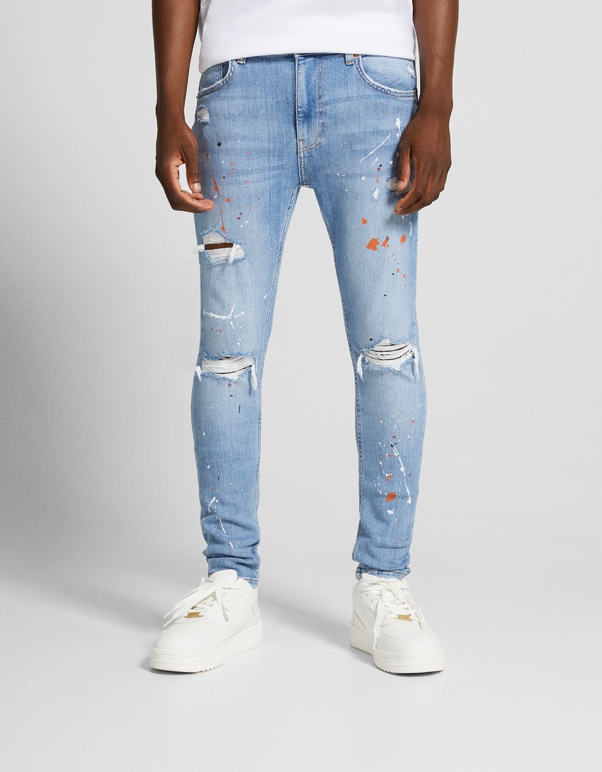 Calça jeans super skinny rasgada com respingos de tinta