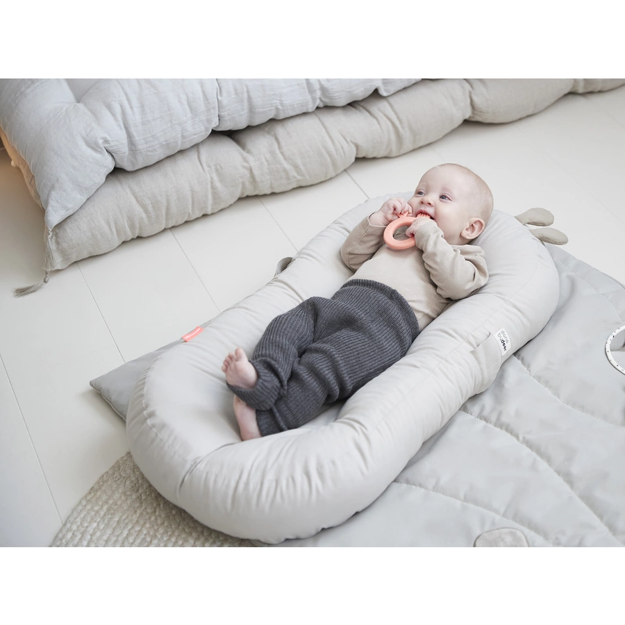 Done by Deer™ Babynest mit Aktivitätsbogen Raffi Sand