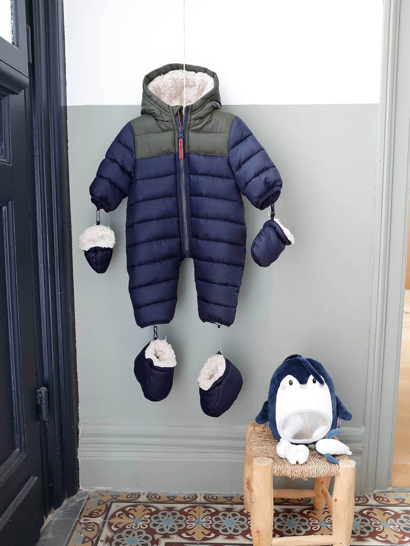 Macacão infantil estilo piloto com forro e acolchoamento em azul escuro liso com estampas.