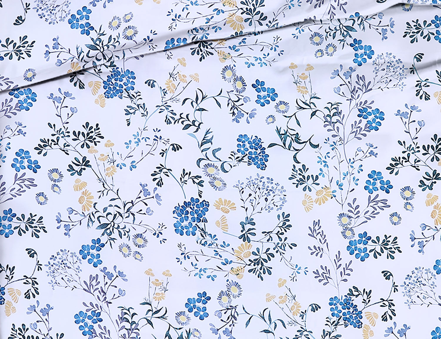 Bettwäsche mit blauem Blumenmuster auf hellem Untergrund