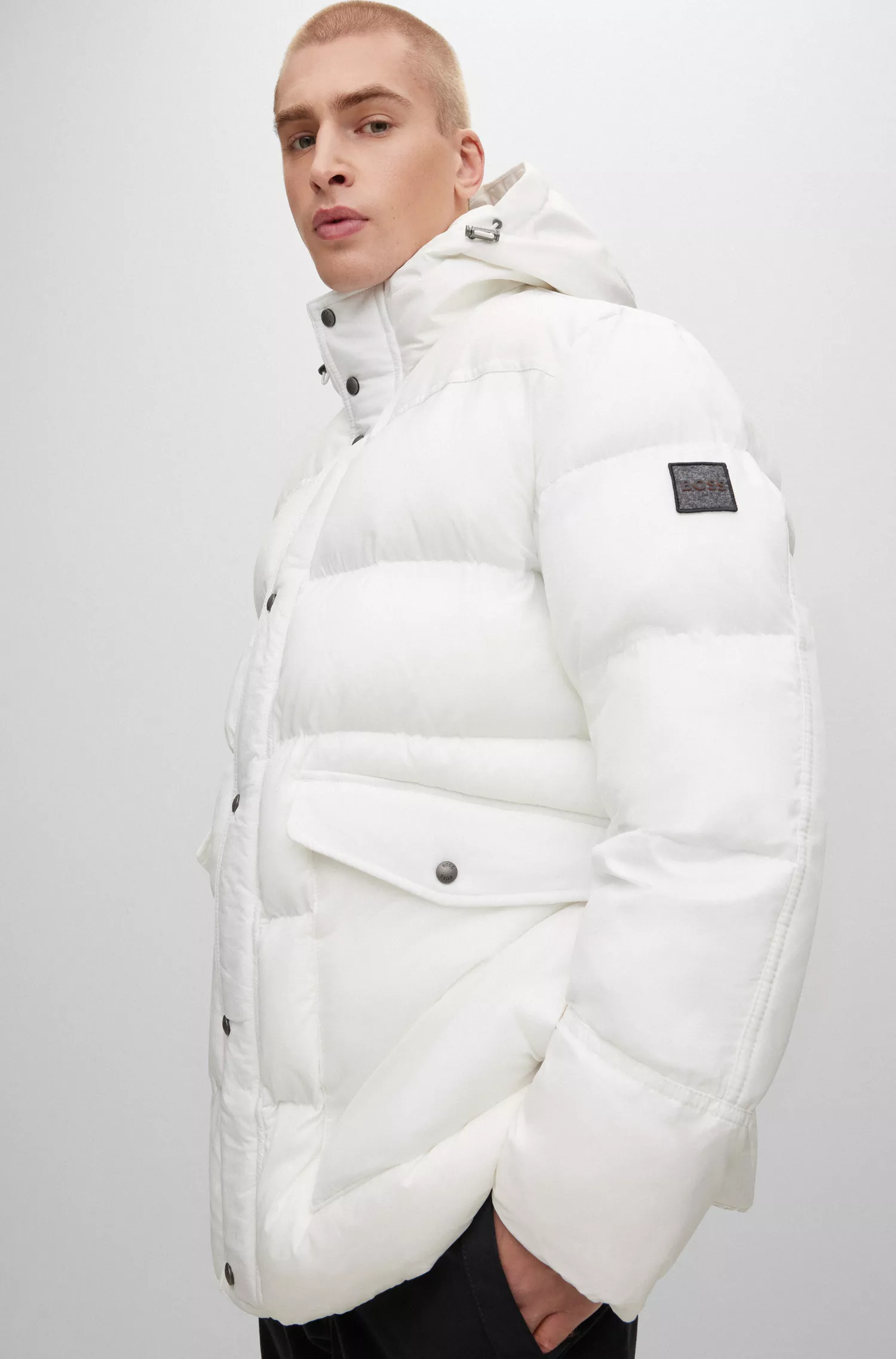 Jaqueta parka BOSS laranja, modelagem relaxada e repelente à água, com emblema da marca.