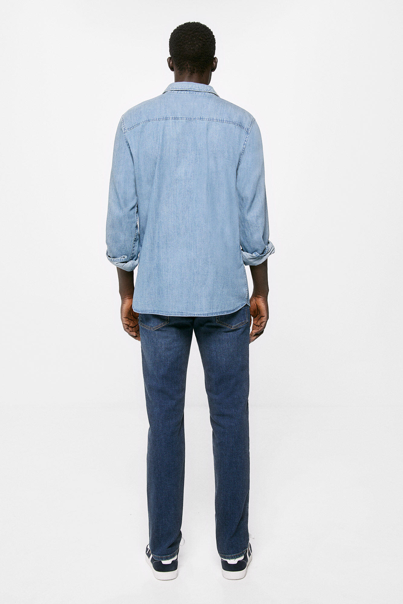 Calça jeans slim, lavagem clara escura, com detalhes desgastados.
