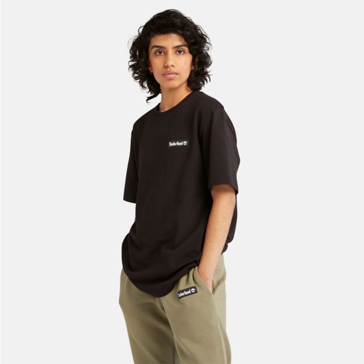 Camiseta unissex de tecido pesado com emblema na cor preta.