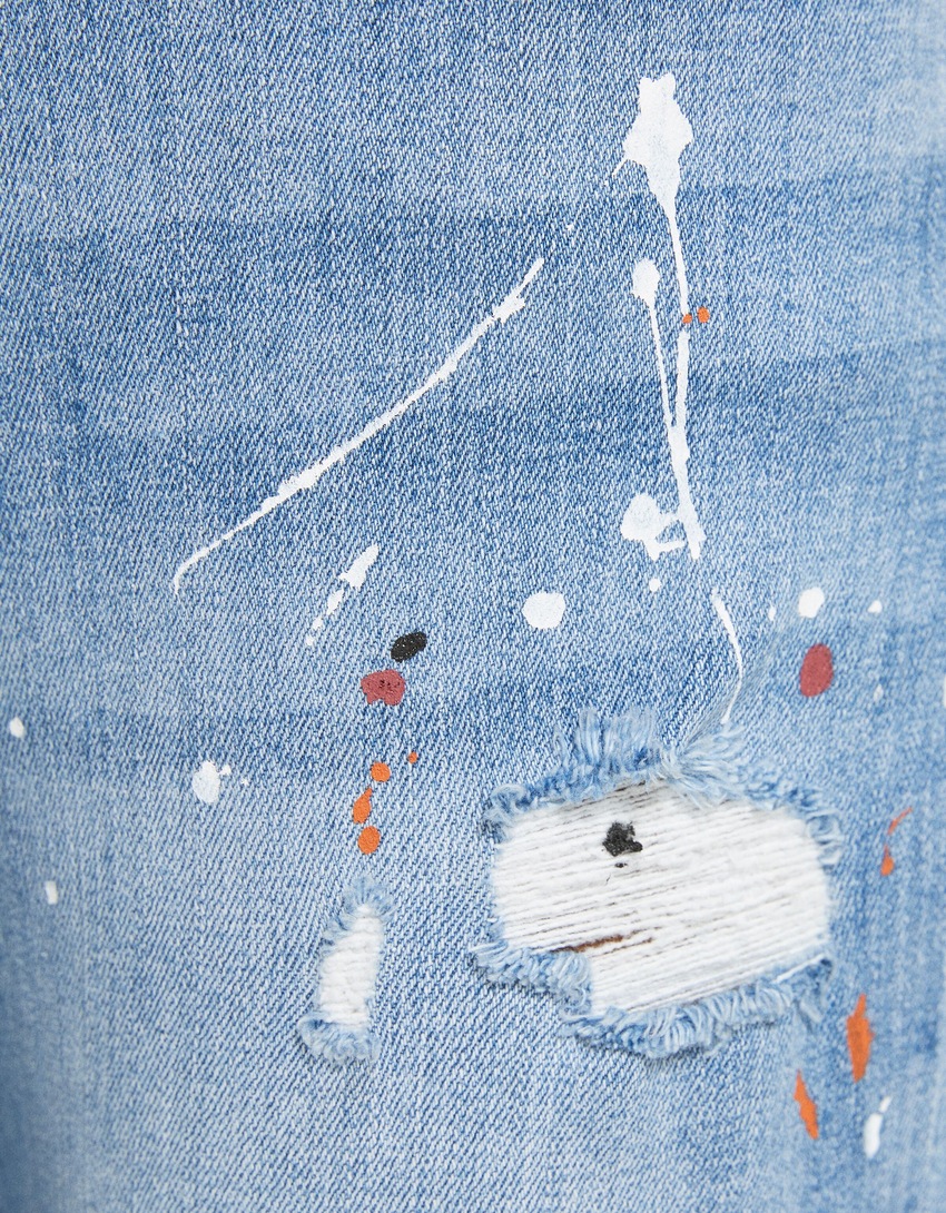 Calça jeans super skinny rasgada com respingos de tinta