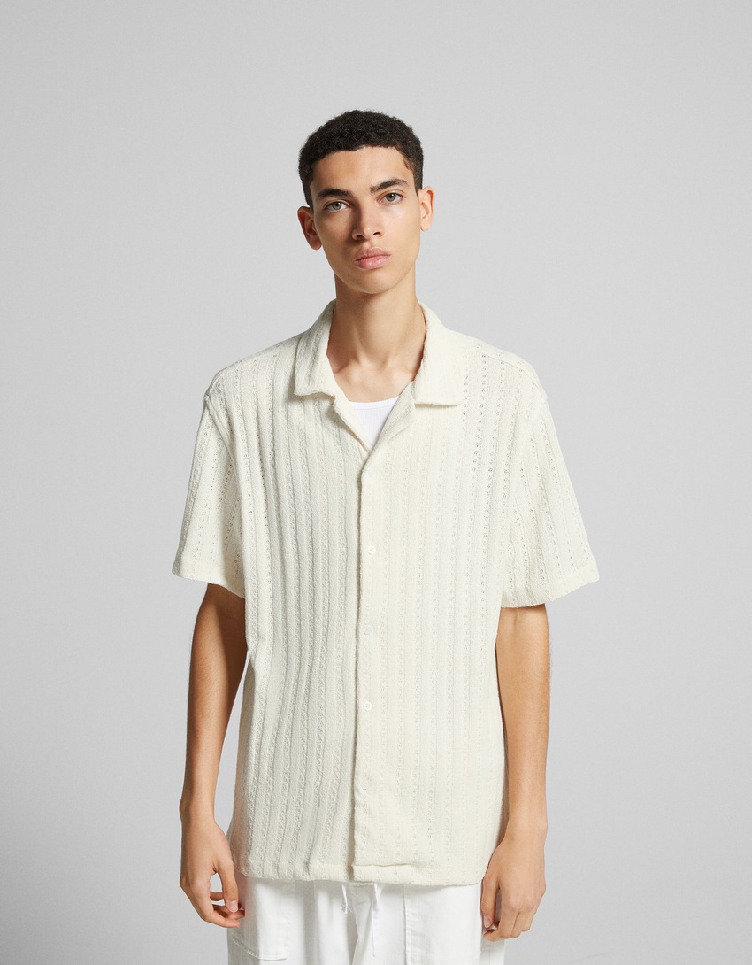 Camisa de malha jacquard aberta com mangas curtas.