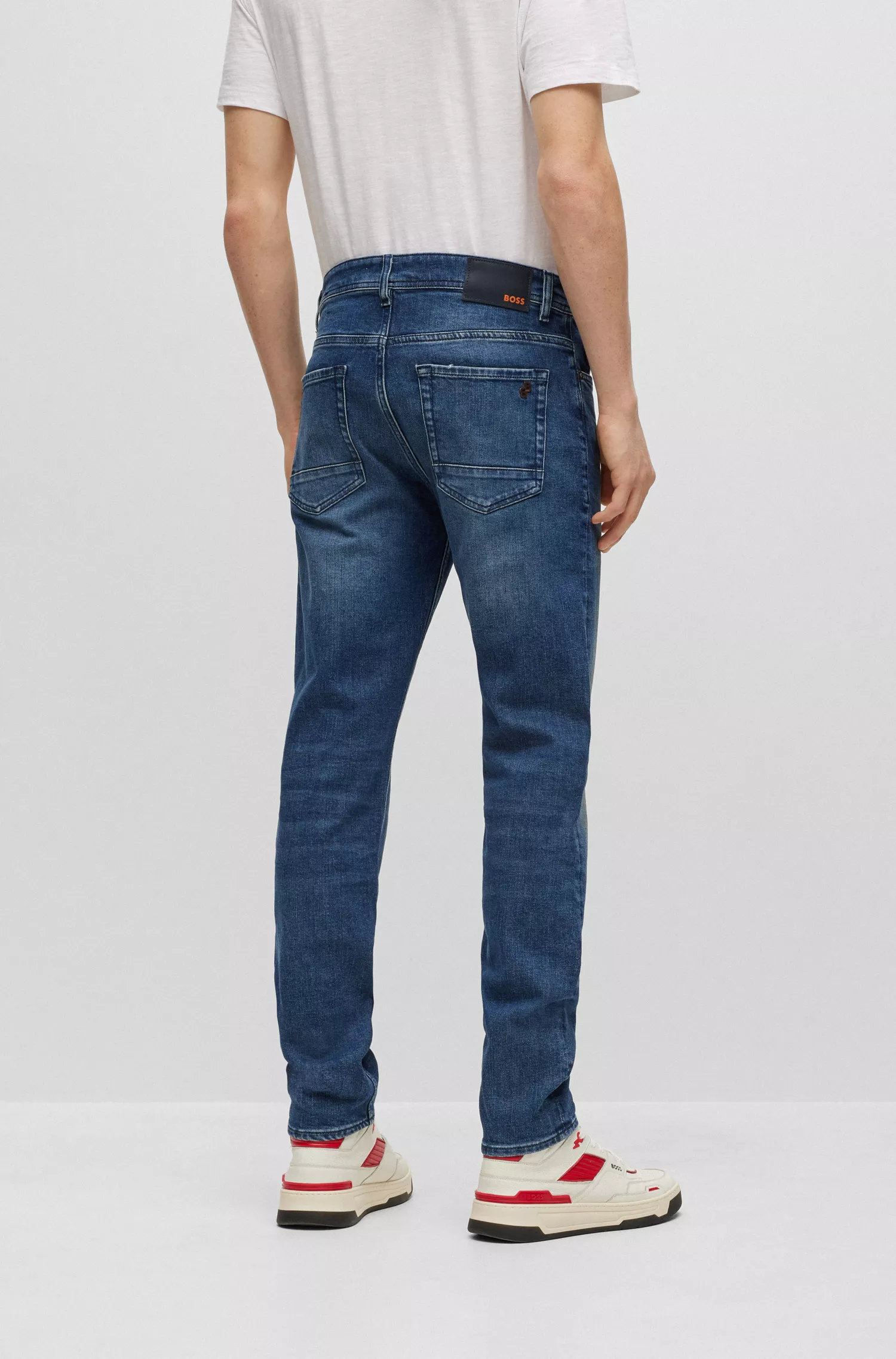 Calça jeans BOSS laranja, corte afunilado, em denim azul com elasticidade confortável.
