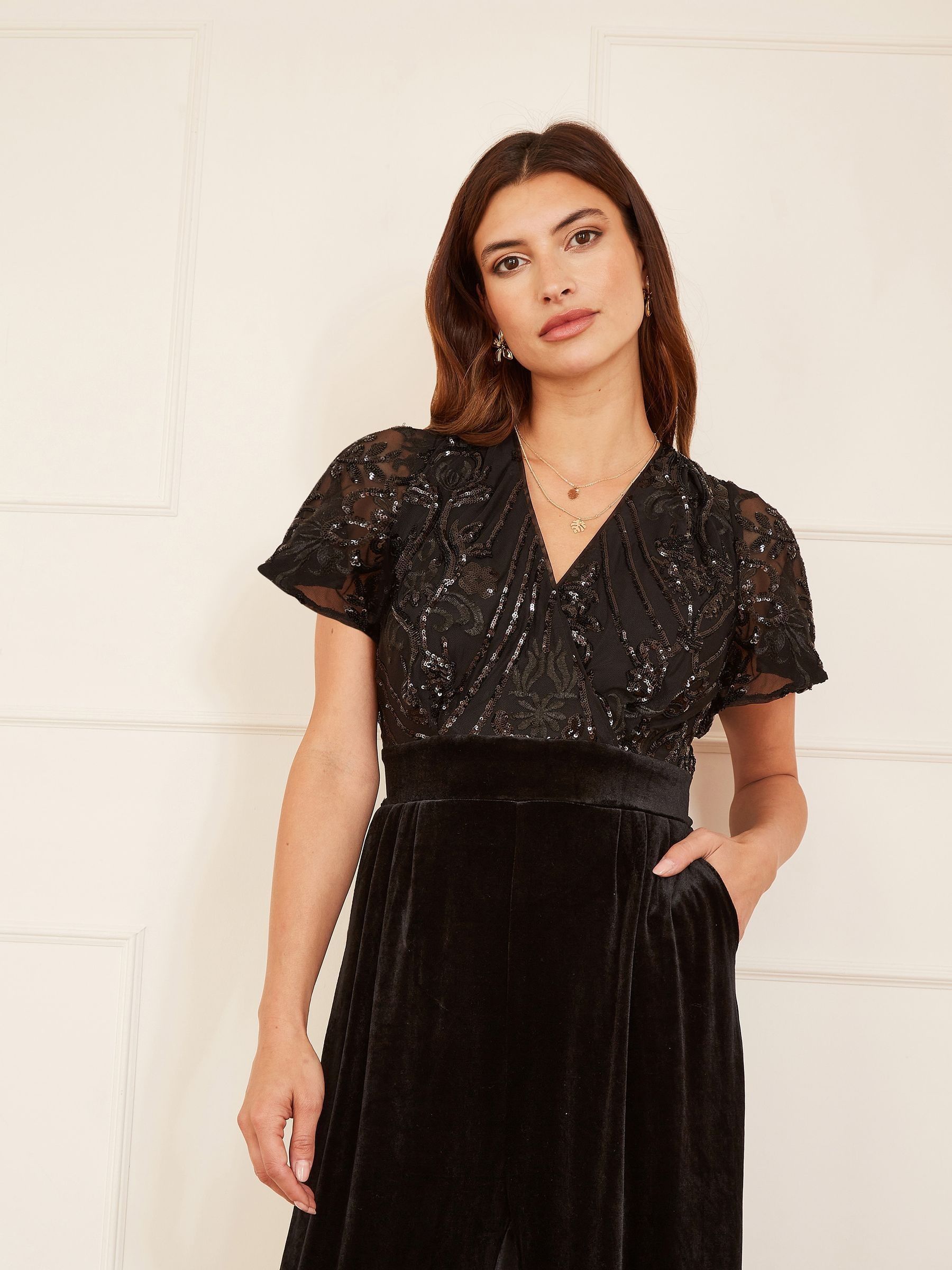 Zwart - Yumi jumpsuit met engelmouwen, van fluweel en versierd met lovertjes
