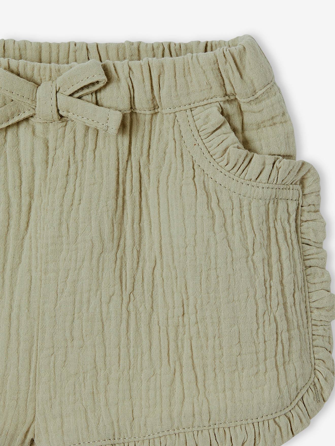 Roupa de bebê: shorts, camiseta listrada e faixa de cabelo verde-acinzentada.