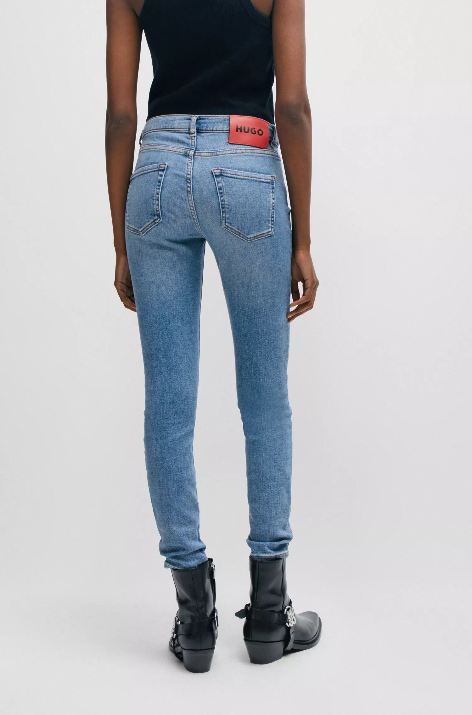 Calça jeans HUGO vermelha, modelo skinny, em denim elástico azul.