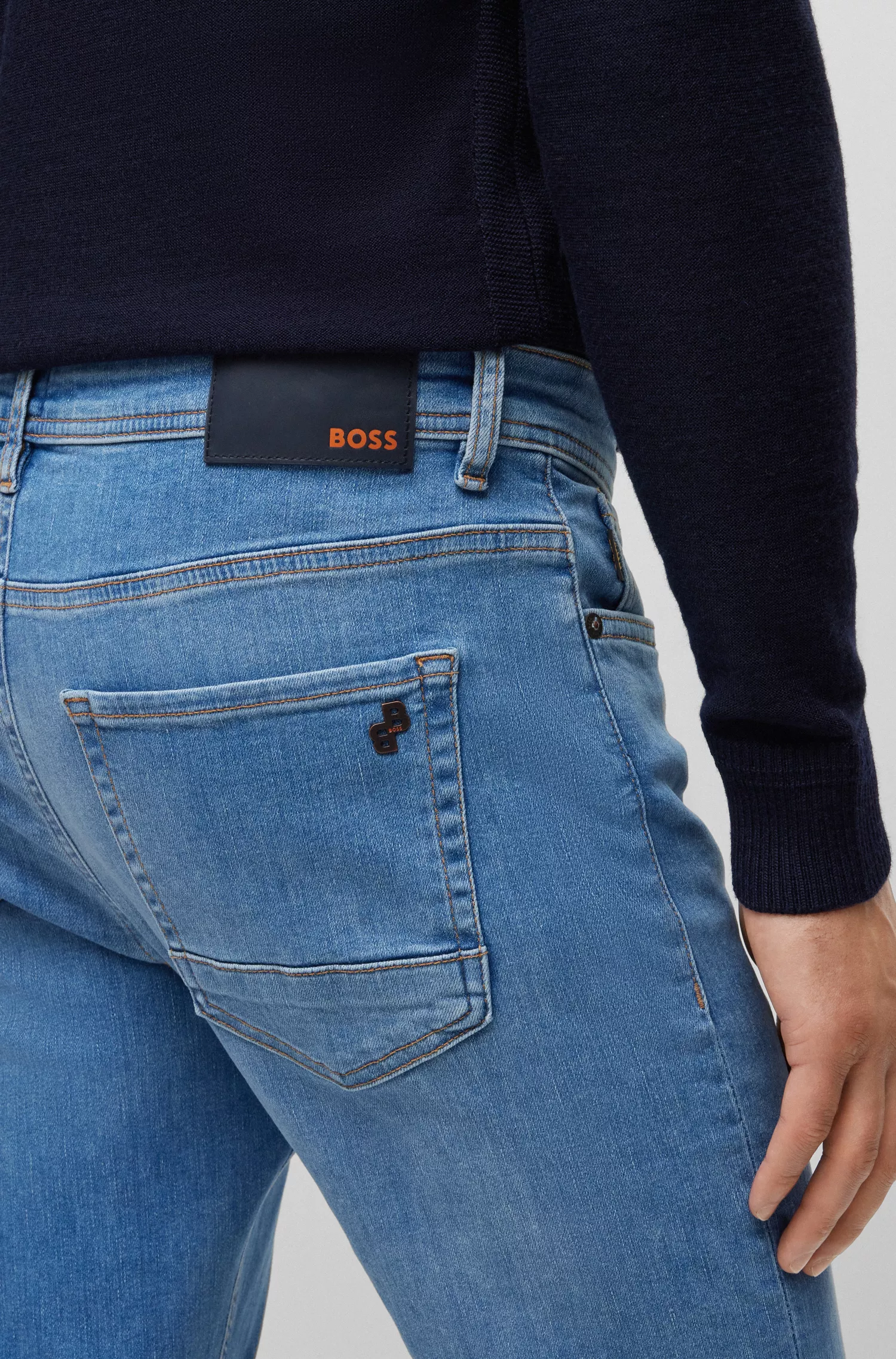 Calça jeans BOSS laranja, corte afunilado, em denim superelástico azul médio.