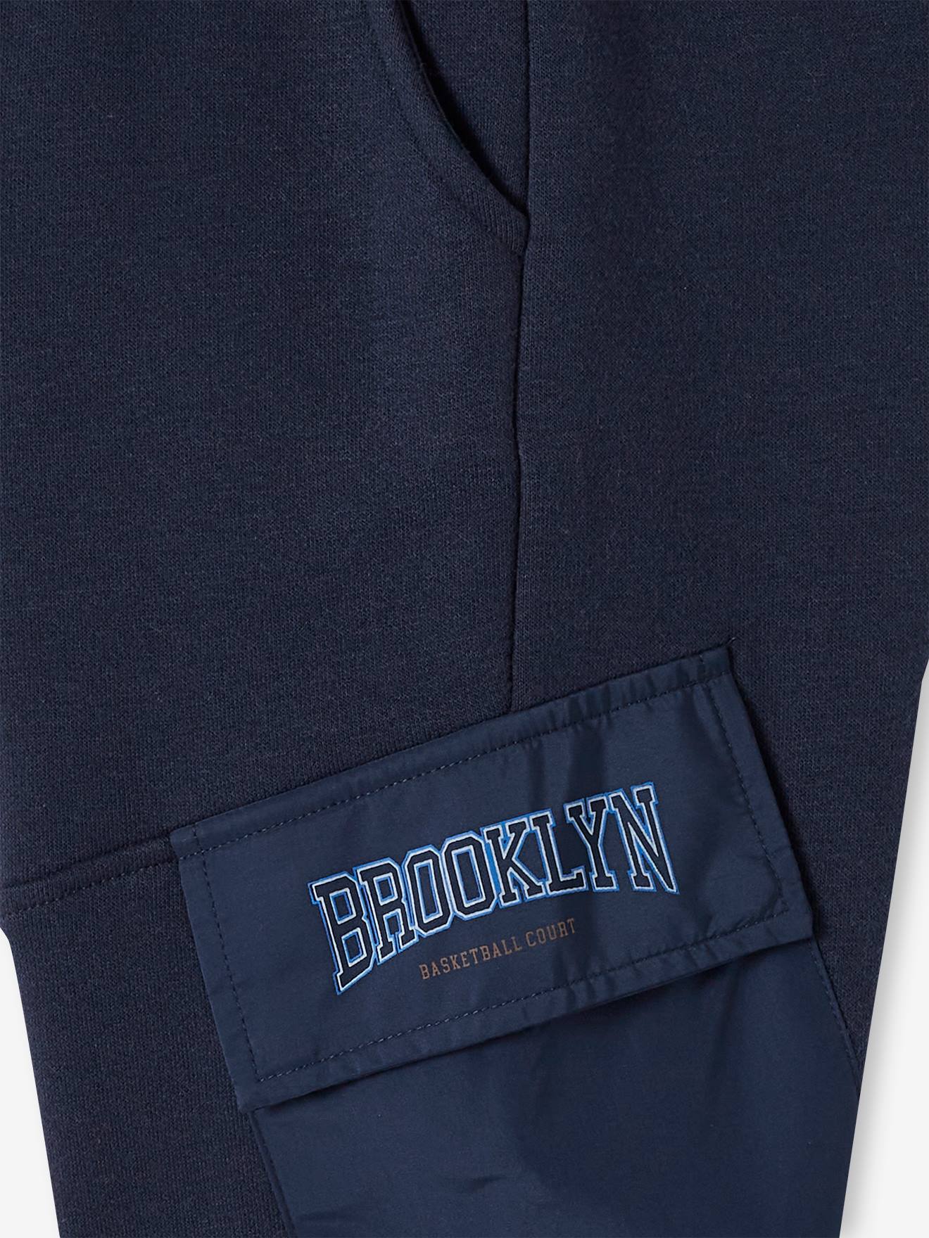 Calça de fato de treino infantil azul-escuro com bolsos de aba.