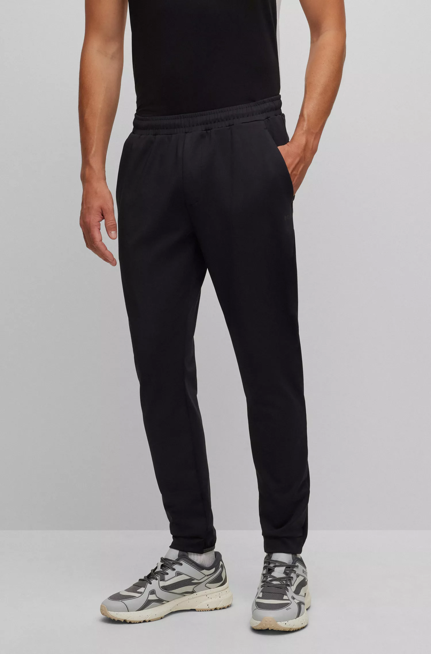 Calça de fato de treino BOSS verde com punhos, em tecido elástico para atividades físicas.