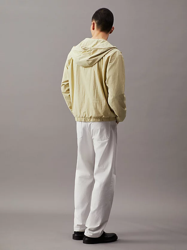 Jaqueta corta-vento de nylon com modelagem folgada e capuz.