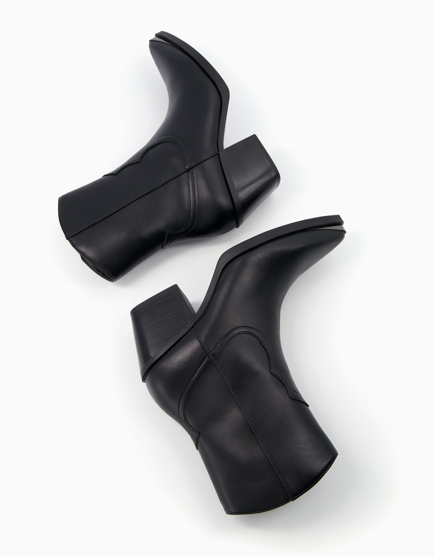Botas de cano curto estilo cowboy com salto e biqueira metálica.