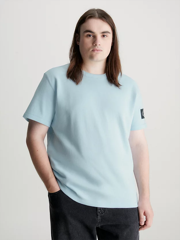 Camiseta de algodão com textura alveolar e modelagem slim, com brasão.