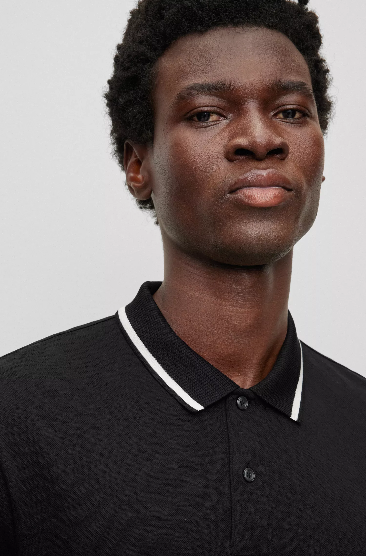 Camisa polo BOSS preta, corte regular, com jacquard de monograma.