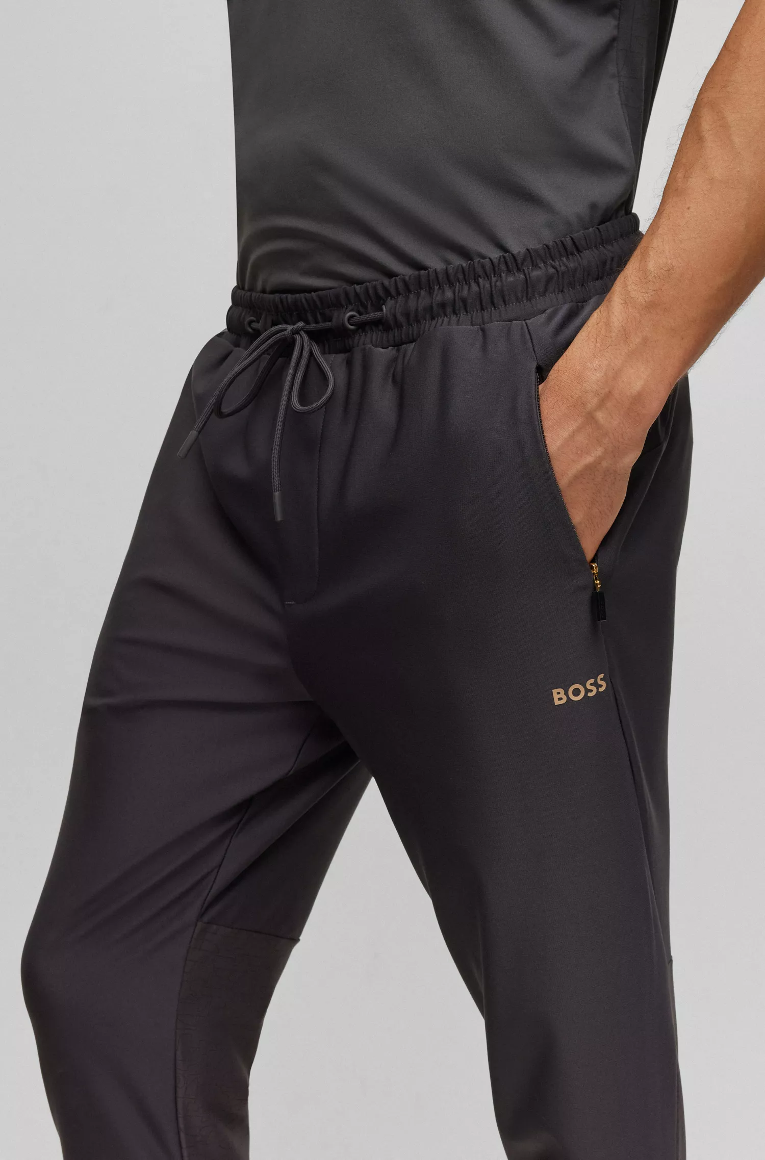 Calça de fato de treino BOSS verde, corte regular, com padrão refletor decorativo.