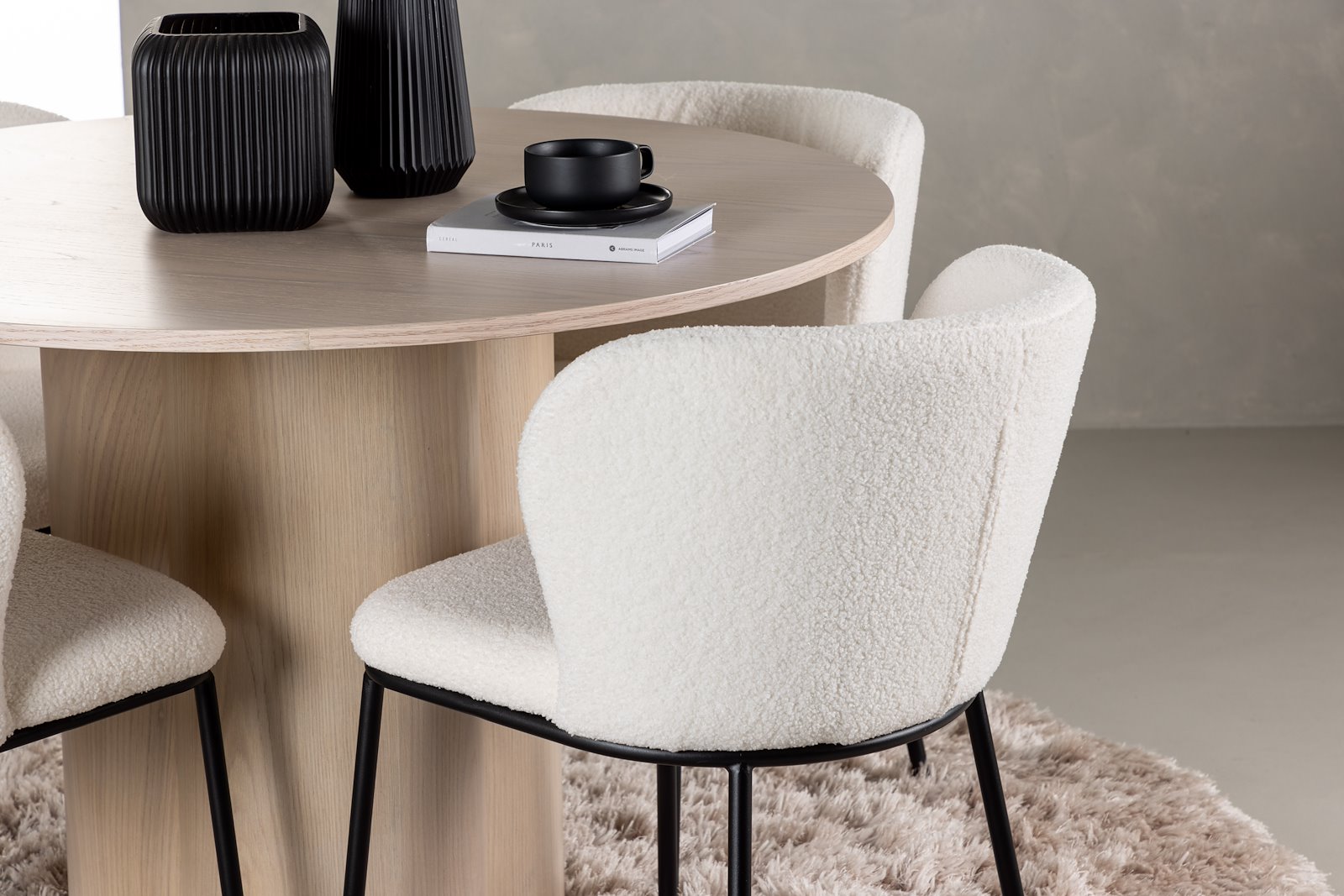 Olivia og Edina Spisegruppe Olivia rundt spisebord Ø110 cm i hvitlasert finer med 4 stk. Edina spisestoler i White bouclé og sorte ben.