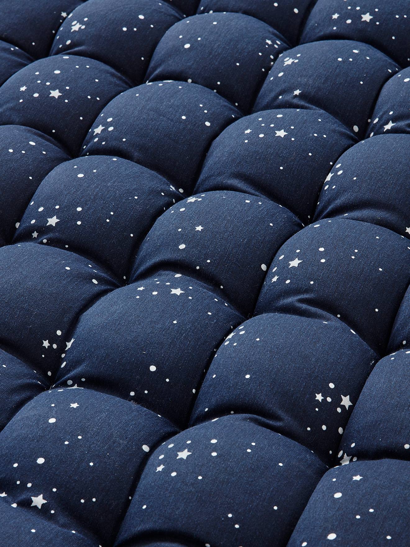 Colchão de chão com franjas estampadas em azul escuro.