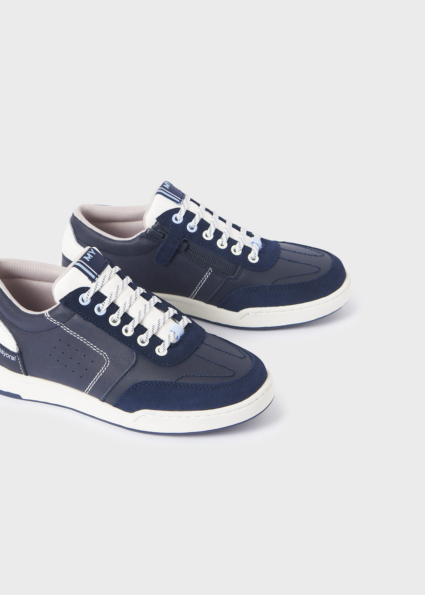 Jaqueta esportiva infantil com zíper lateral e detalhes perfurados.
