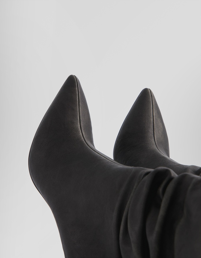 Botas de cano curto com salto agulha e modelagem folgada