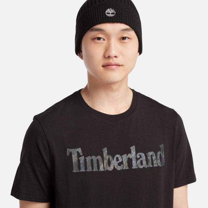Camiseta masculina preta com estampa camuflada e logo.