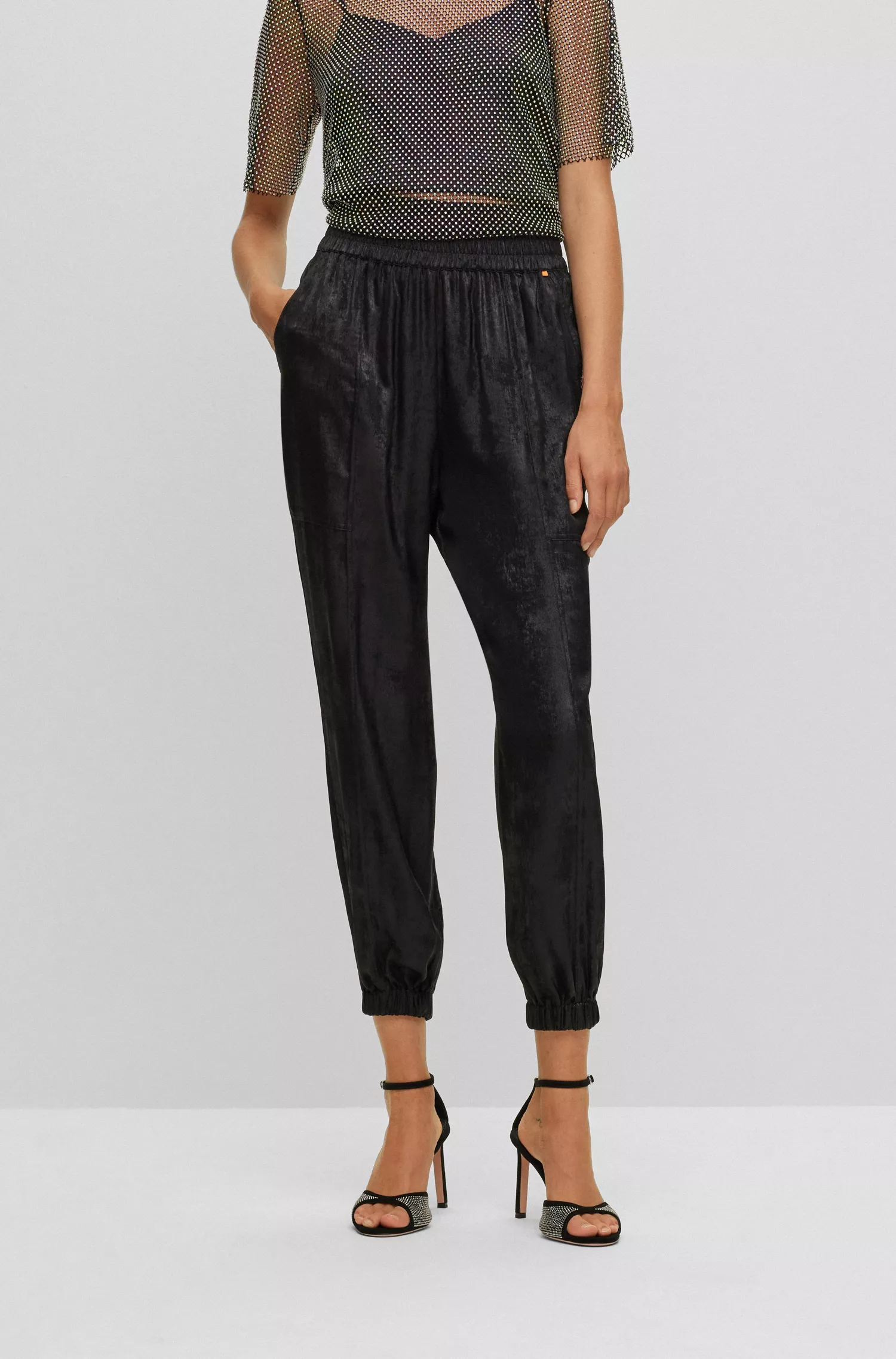 Calça BOSS laranja, corte folgado, com estampa de efeito metálico.