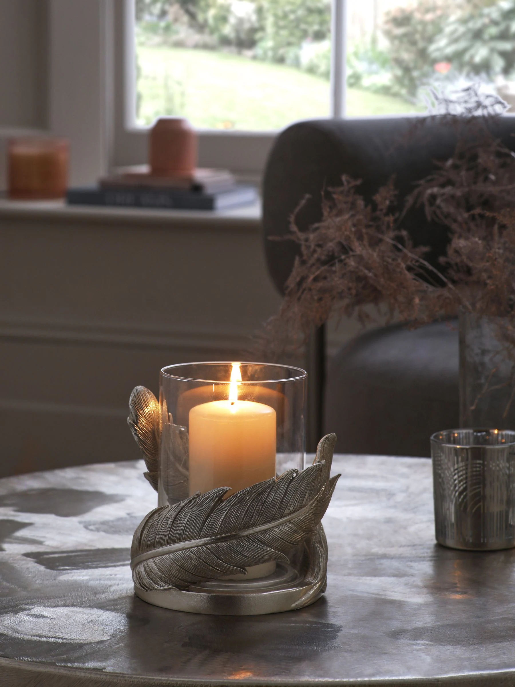 Windlicht van hars en glas met veren