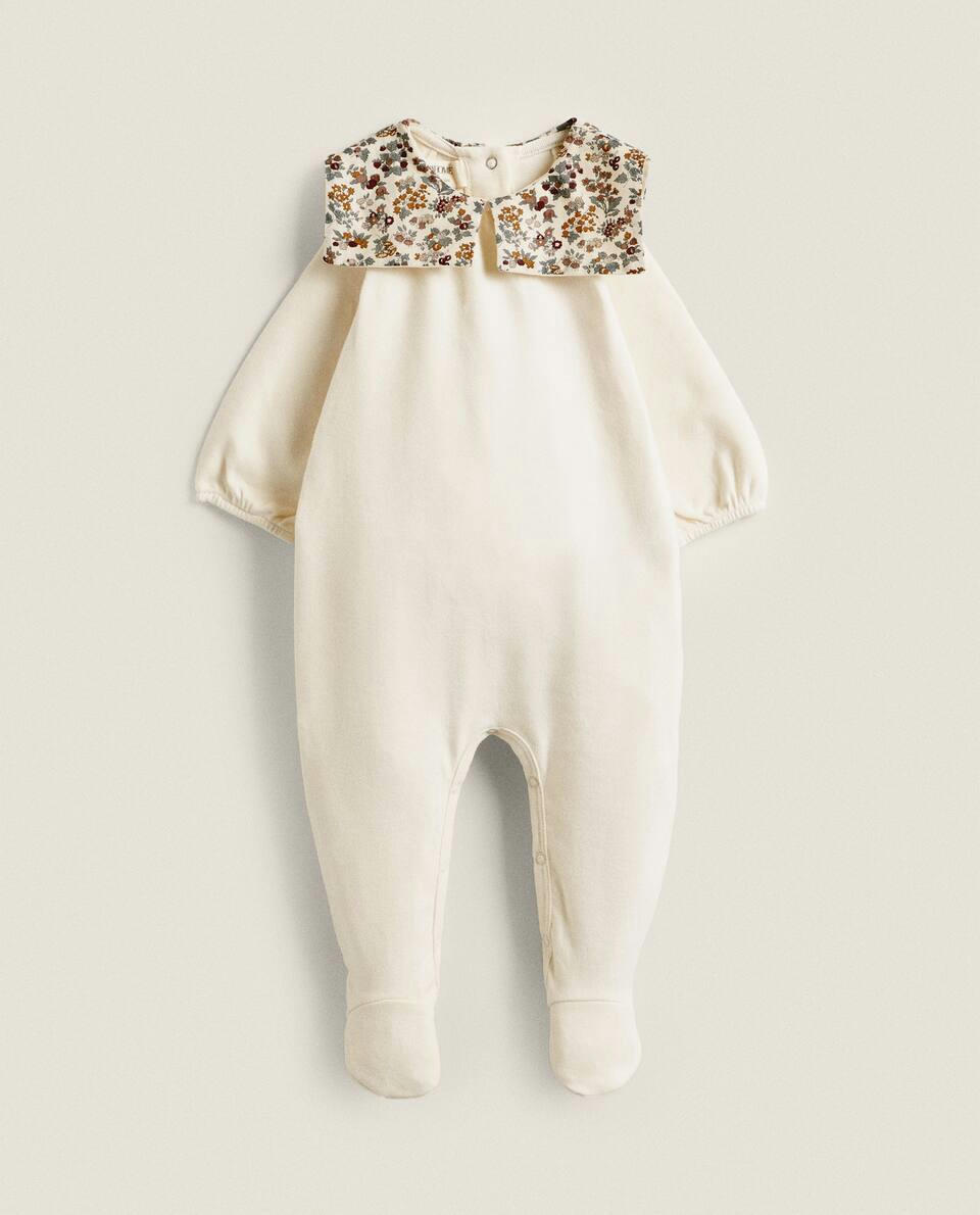 Macacão infantil em tecido com estampa floral e detalhe de gola.