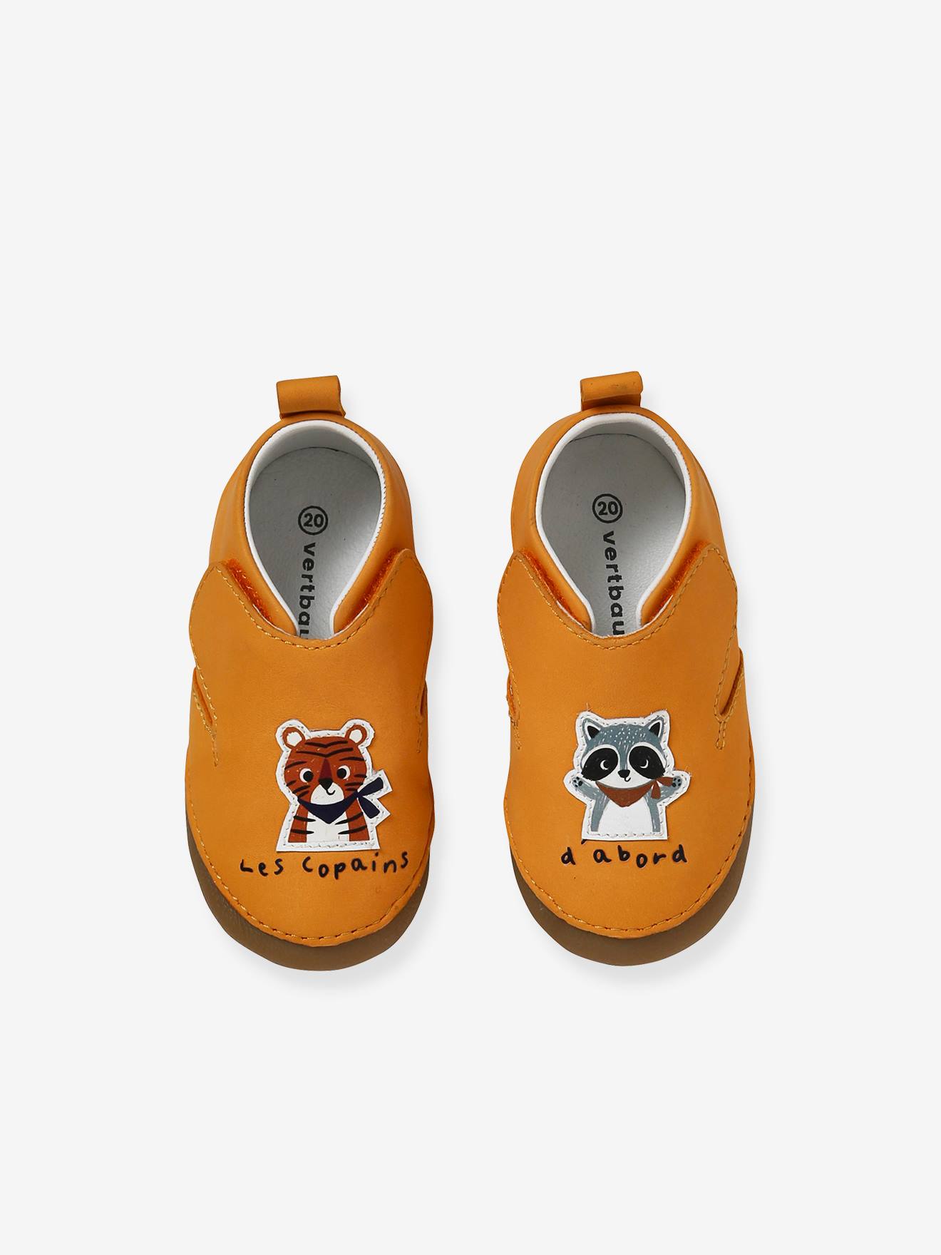 Pantufas amarelas para bebê, feitas de couro flexível com fecho de velcro.