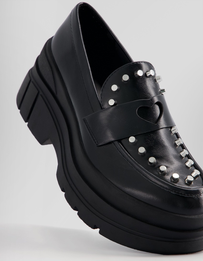Mocassins com tachas e solado grosso.