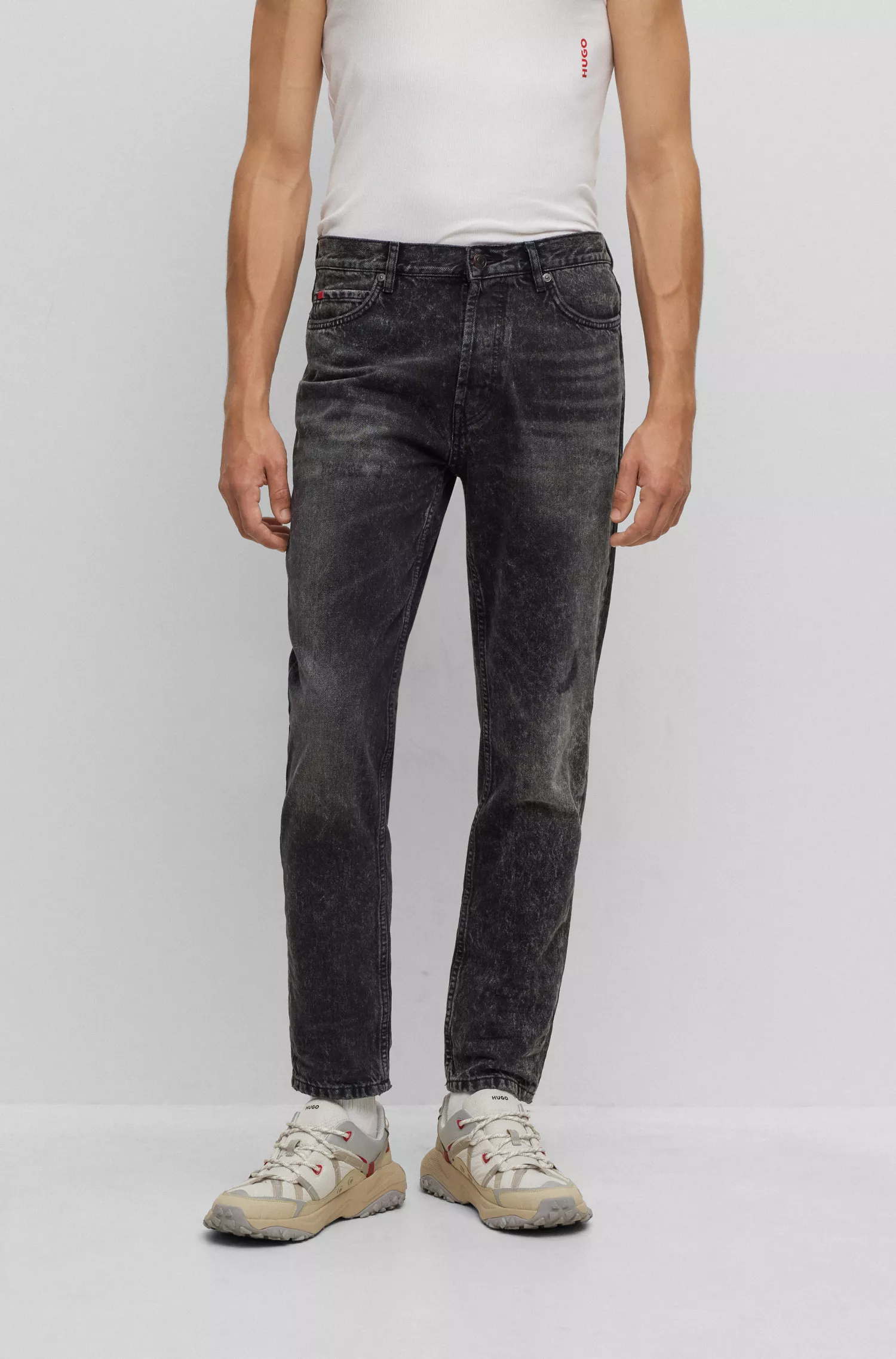 Calça jeans HUGO vermelha, corte afunilado, em denim rígido preto.