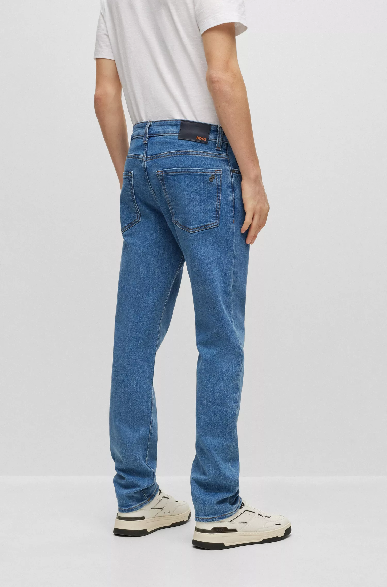 Calça jeans BOSS laranja, corte regular, em denim azul com elasticidade confortável.