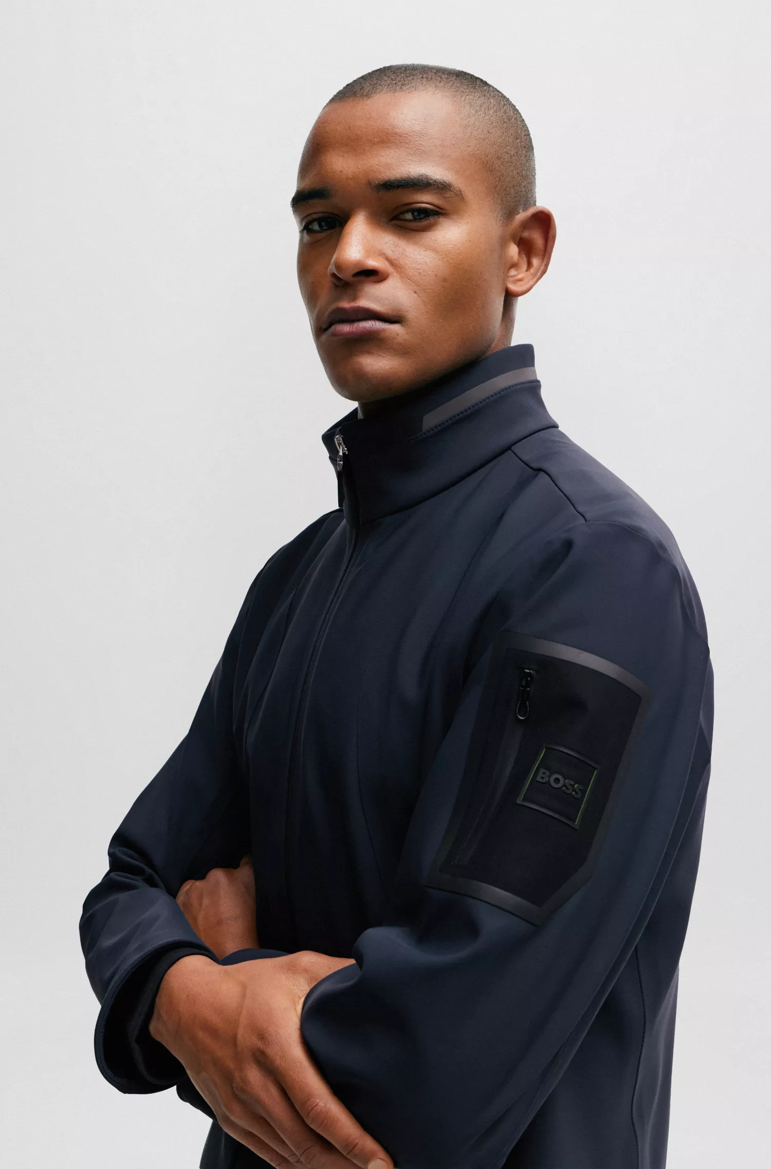 Jaqueta softshell verde-repelente à água da BOSS com bolso na manga com a marca.