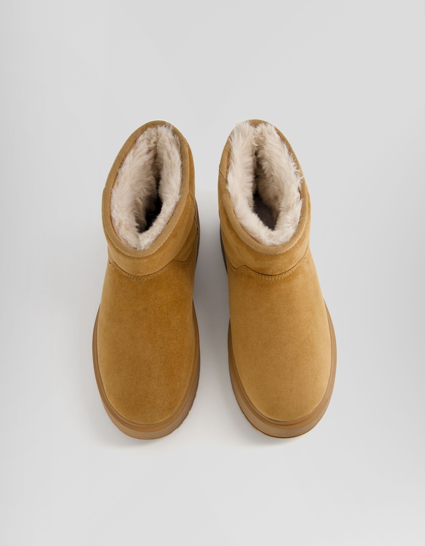Botas de cano curto com plataforma e forro de pele sintética.