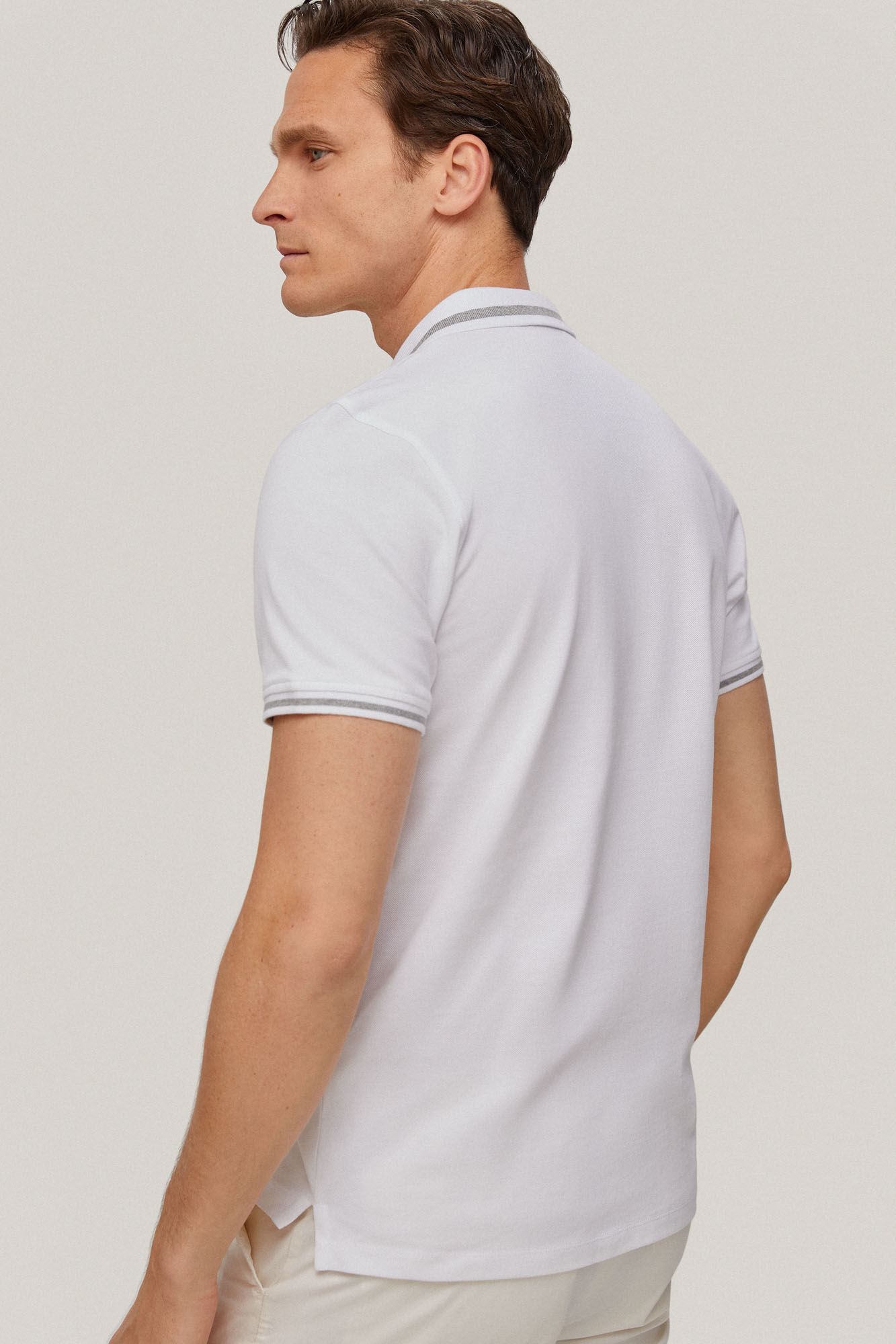 Camisa polo com gola pontuda e logotipo na cor branca.