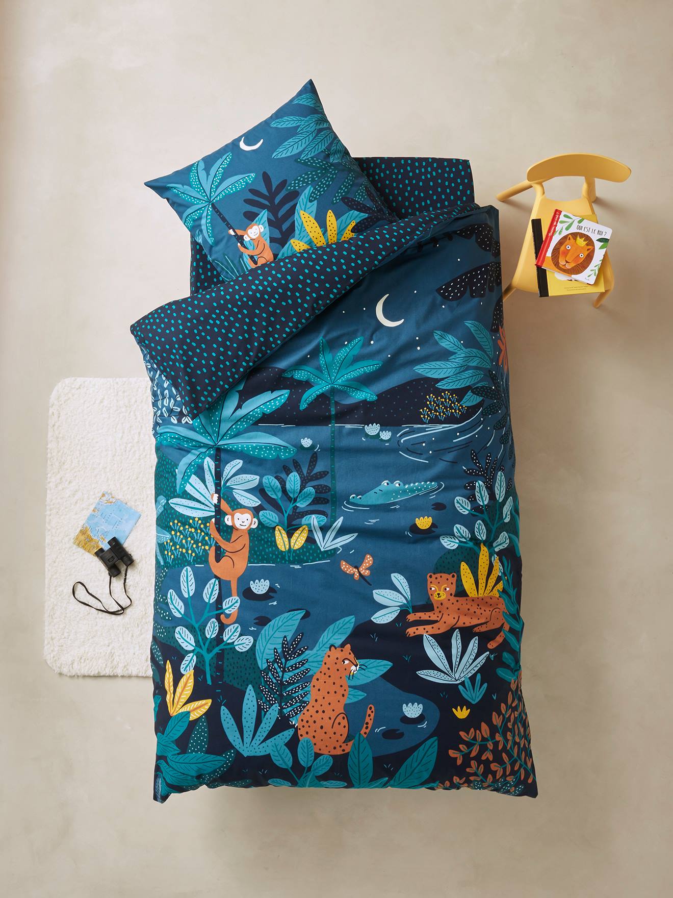 Conjunto infantil Jungle Night com capa de edredom e fronha, azul escuro liso com estampas.