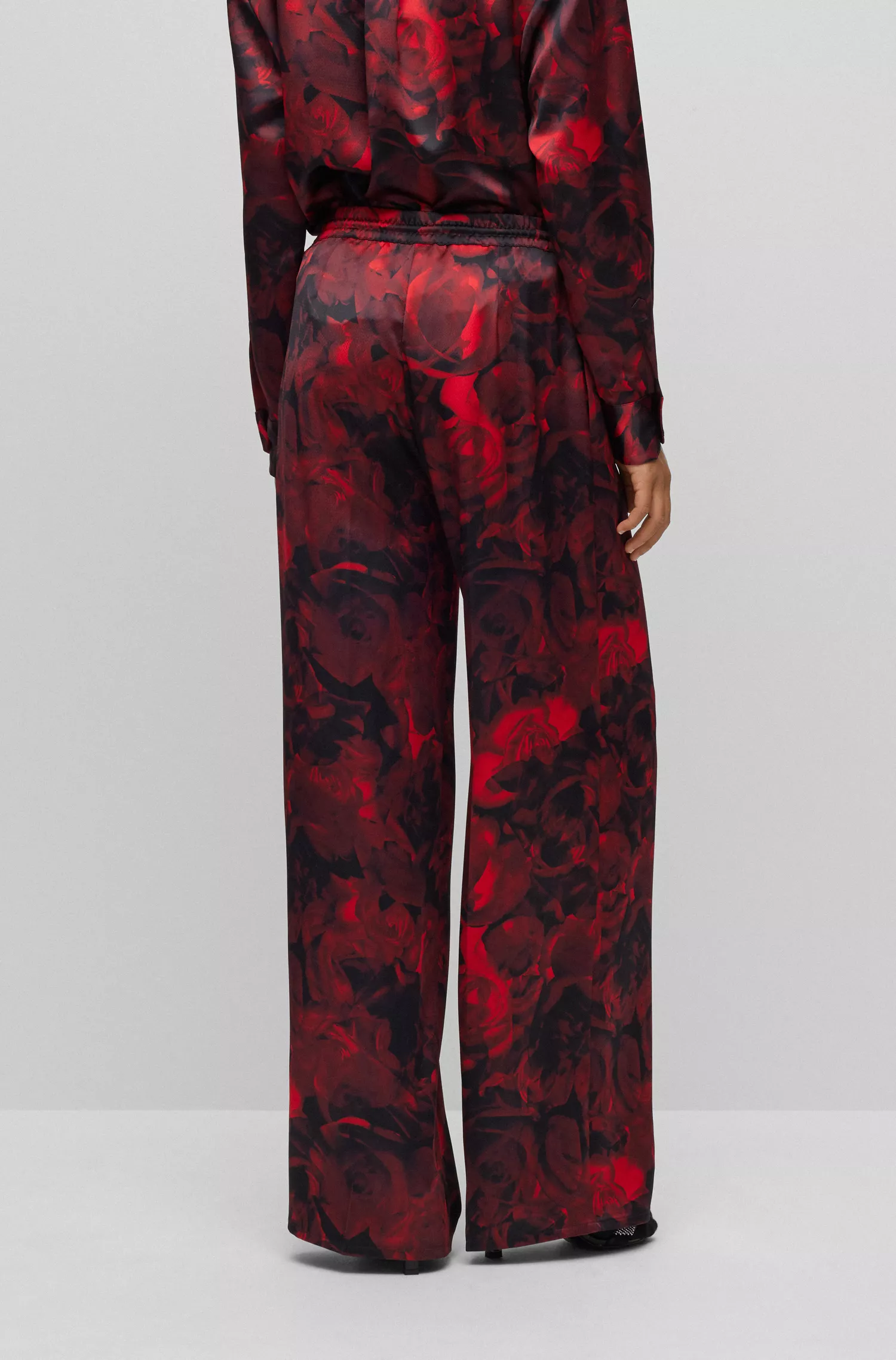 Calça HUGO vermelha de pernas largas e corte relaxado com estampa de rosas.