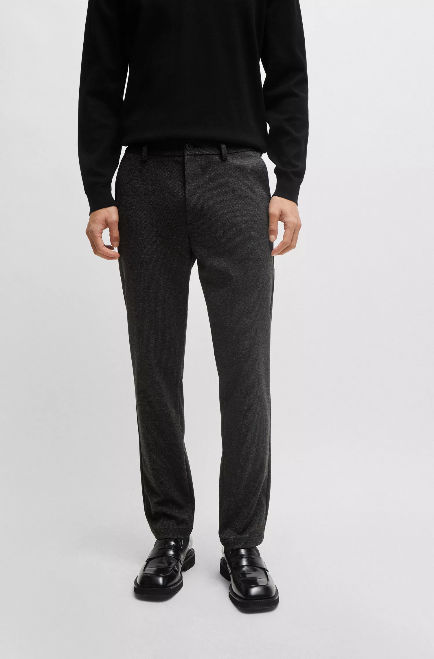 Calça BOSS preta, corte slim, em tecido estruturado de alta performance com elasticidade.