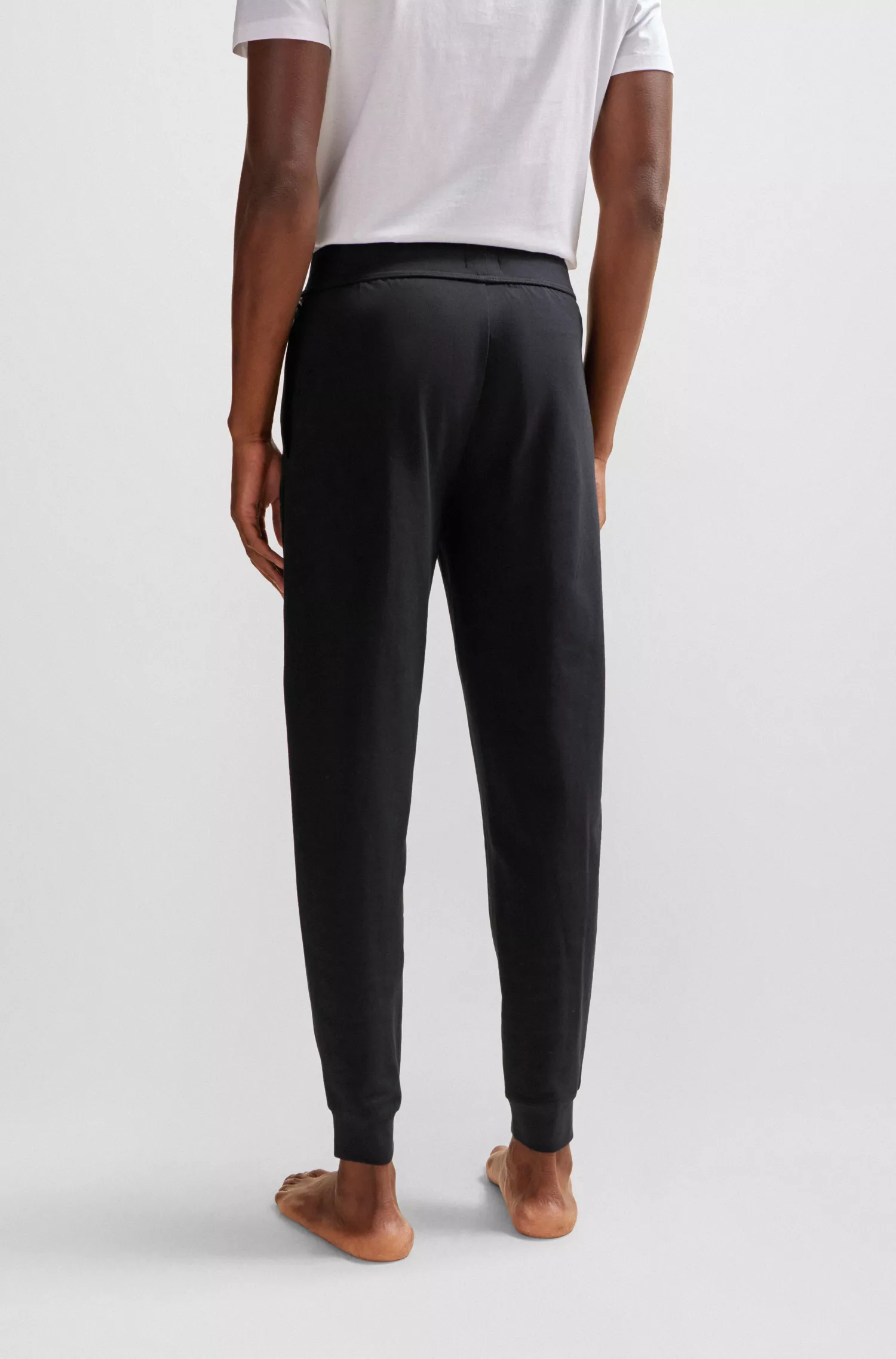 Calça de fato de treino BOSS preta com punhos, em tecido felpudo francês e estampa com o logótipo.
