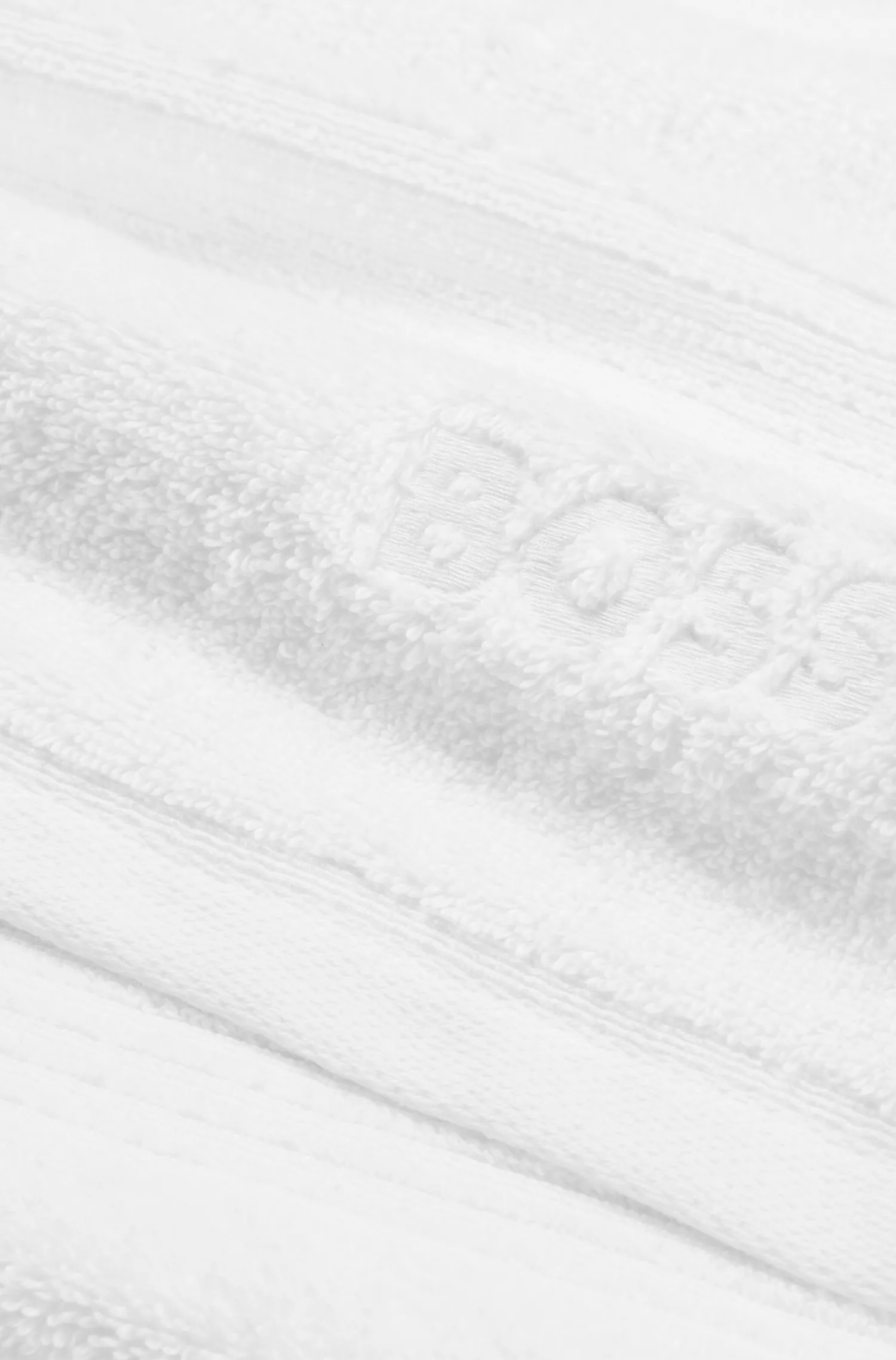 Toalha de banho BOSS em algodão Aegean preto e branco com logotipo tonal.