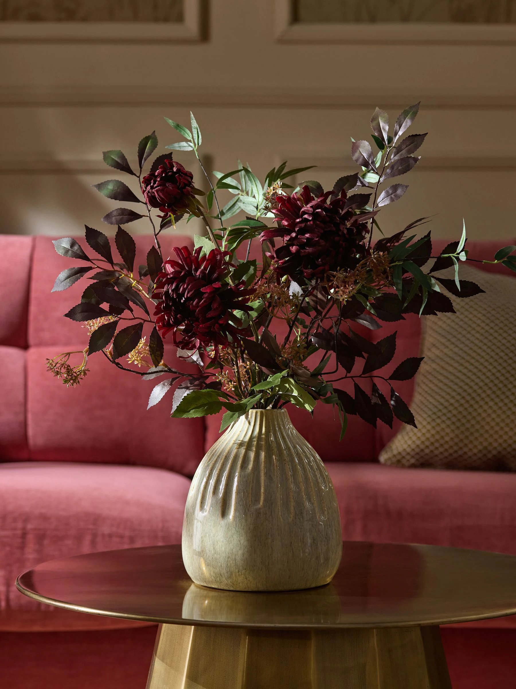 Kunstbloemstuk met donkere bloemen in keramische vaas