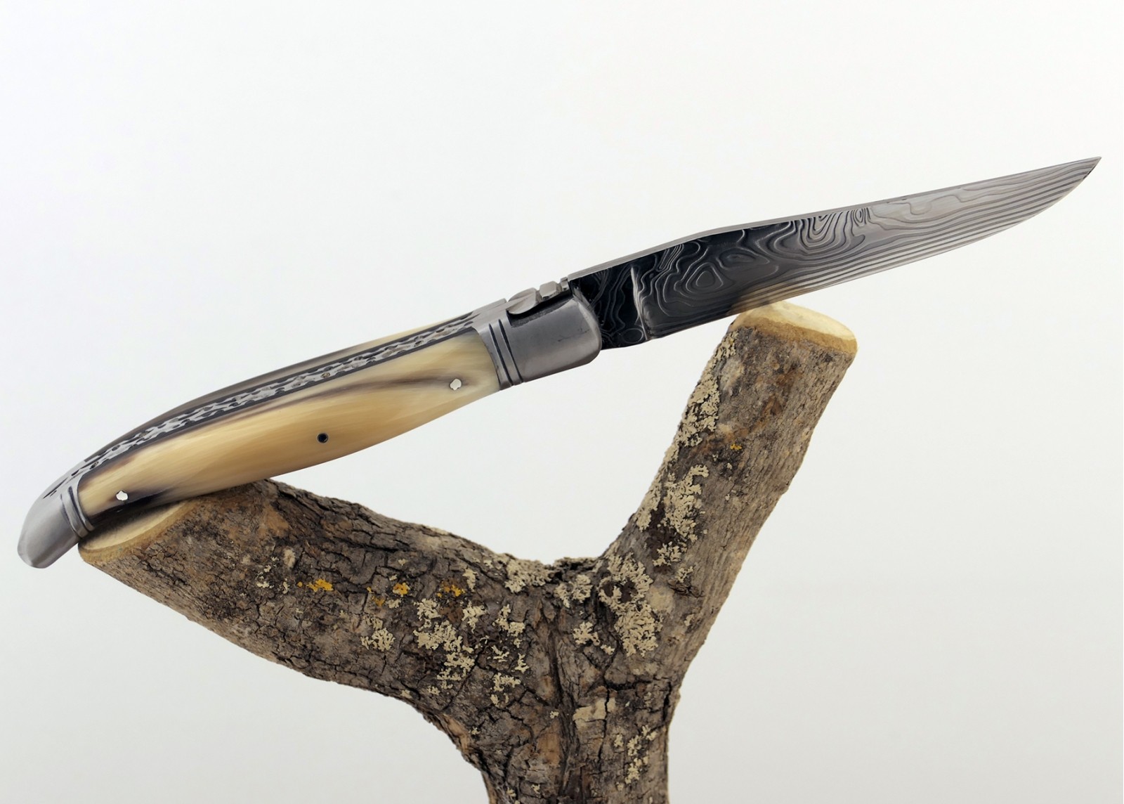 Couteau Laguiole prestige avec un manche en pointe de corne blonde et mitres en acier inoxydable et lame Damas