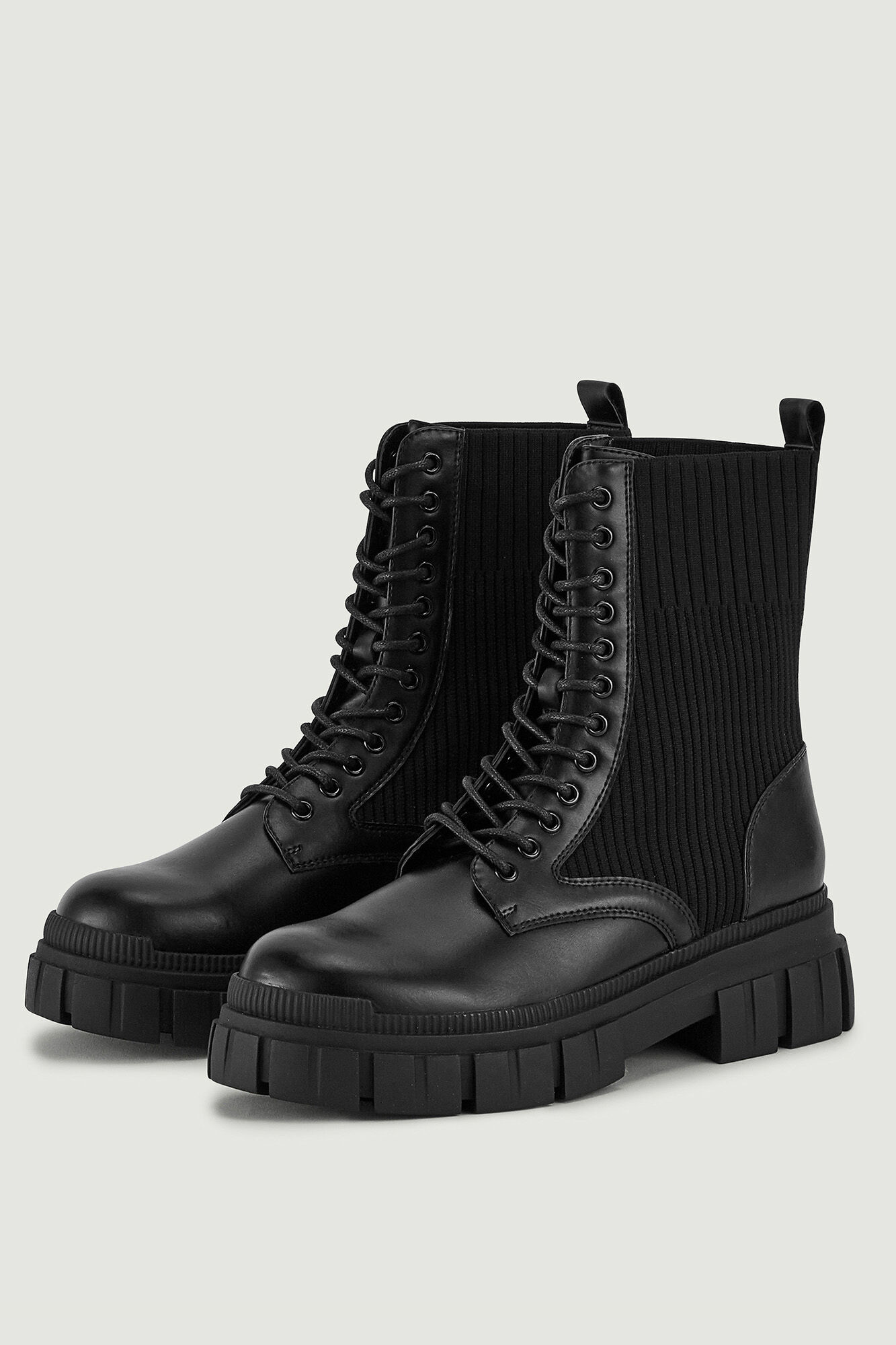 Botas de cano curto em imitação de couro com cadarços e sola serrilhada.