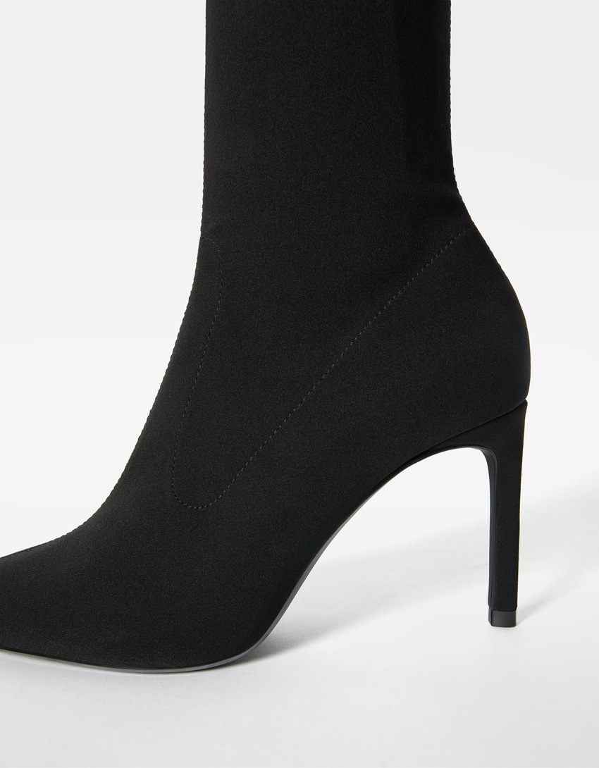 Botas de cano curto com salto alto e modelagem ajustada