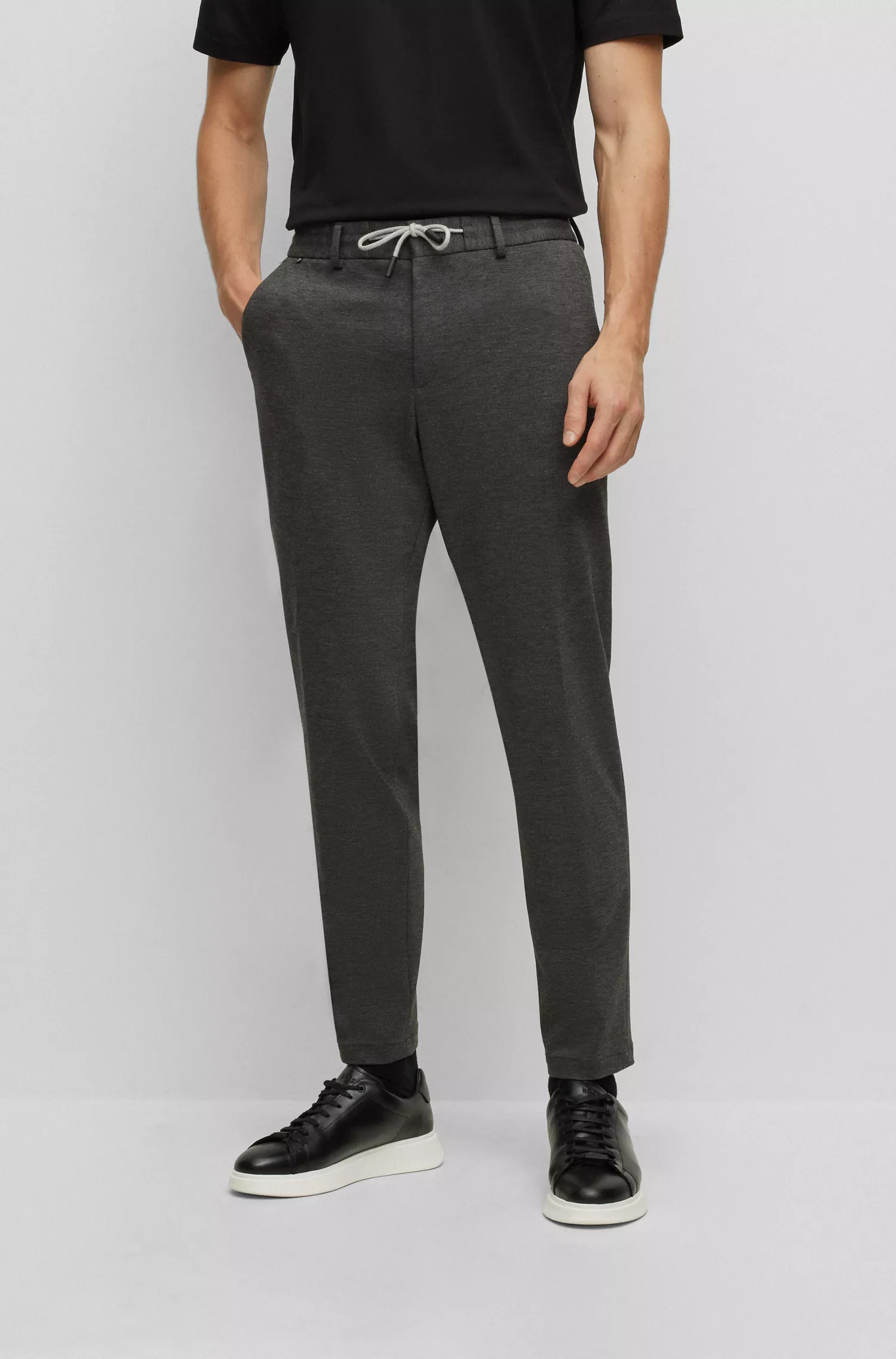 Calça BOSS preta, corte slim, em malha interlock de alta performance com elasticidade.