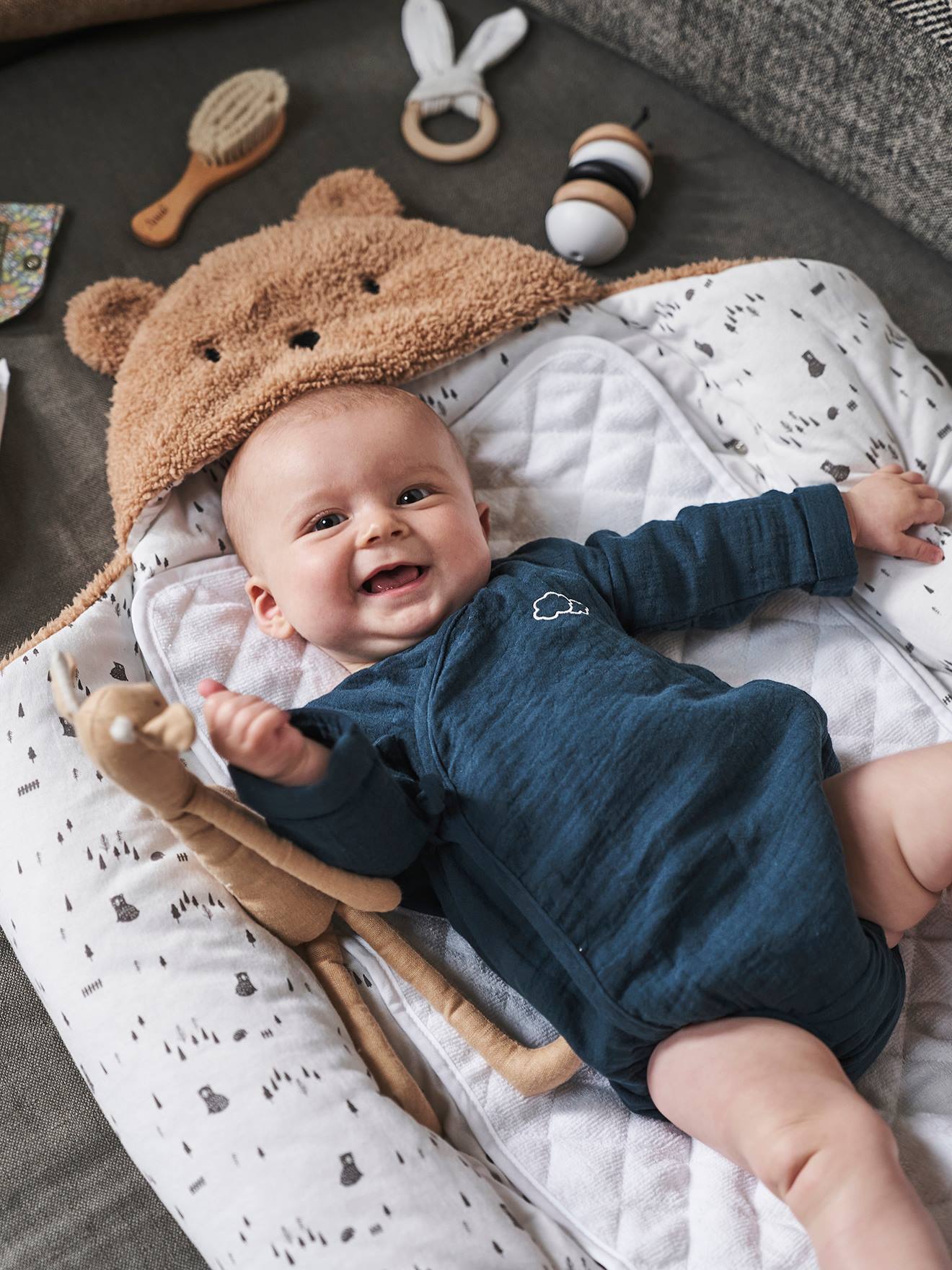 Saco transformável em brinquedo de pelúcia. Urso de pelúcia liso bege claro com estampas.