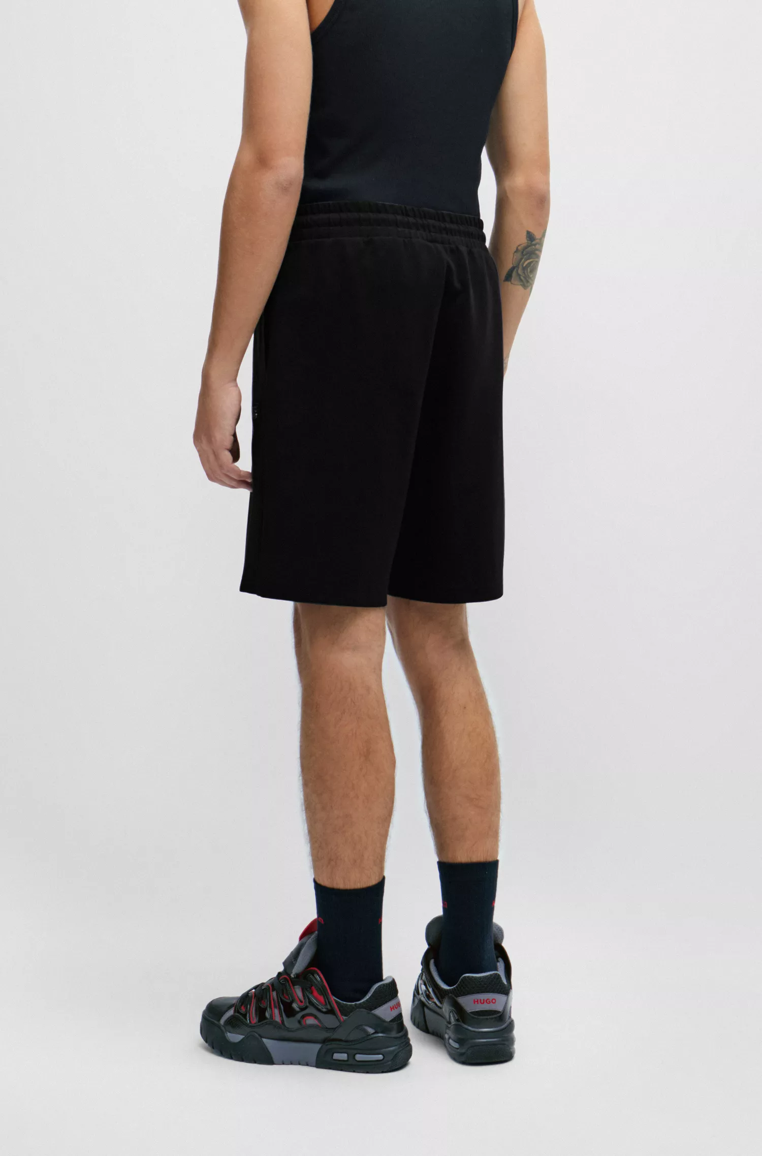 Calções HUGO vermelhos de corte relaxado em algodão elástico com bolsos contrastantes.